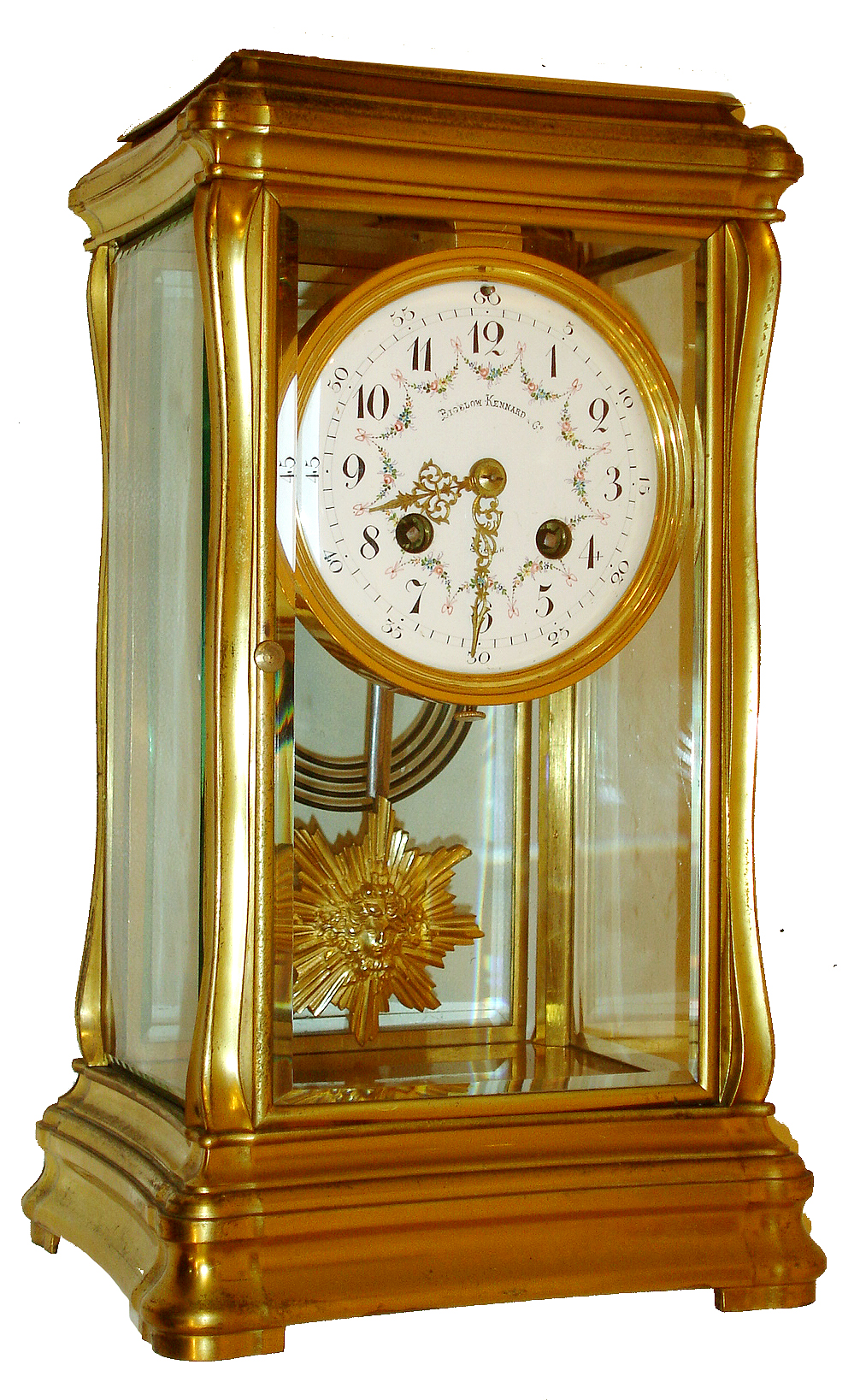 French crystal regulator for Bigelow, Kennard & Co., Boston, gilt brass case with subtle Art Nouveau styling, the top and base with gently incurved sides, and with moldings similar to a Gorge style carriage clock, beveled glass panels, Arabic numeral white enamel dial with polychrome floral swags, gilt Louis XV style hands, gilt sunburst pendulum with mask, 8 days, time and strike, Pendule a Paris movement with Brocot escapement, and marked Japy Freres, c1900 — Antique Clocks Price Guide