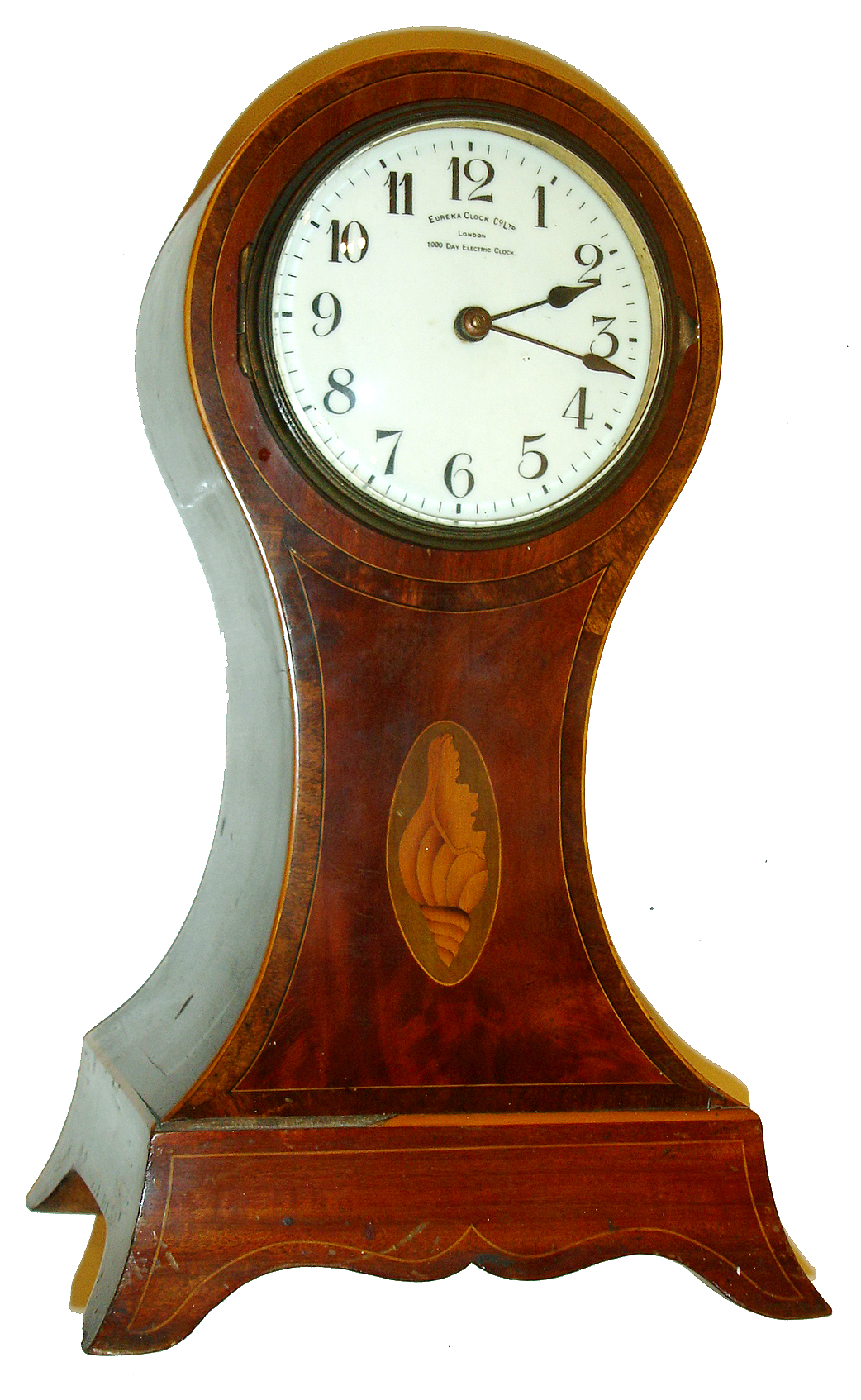 Eureka Clock Co., Ltd., London, 1000 day electric clock in a mahogany veneered Sheraton style balloon case, with line inlays, cross banding and marquetry conch shell, brass bezel with convex beveled glass, Arabic numeral white enamel dial signed "Eureka Clock Co., Ltd., London, 1000 Day Electric Clock", blued steel spade hands, spotted brass movement with large bimetallic balance, the rating assembly accessed through a brass cover in the case back, serial #2847, c1910 — Antique Clocks Price Guide