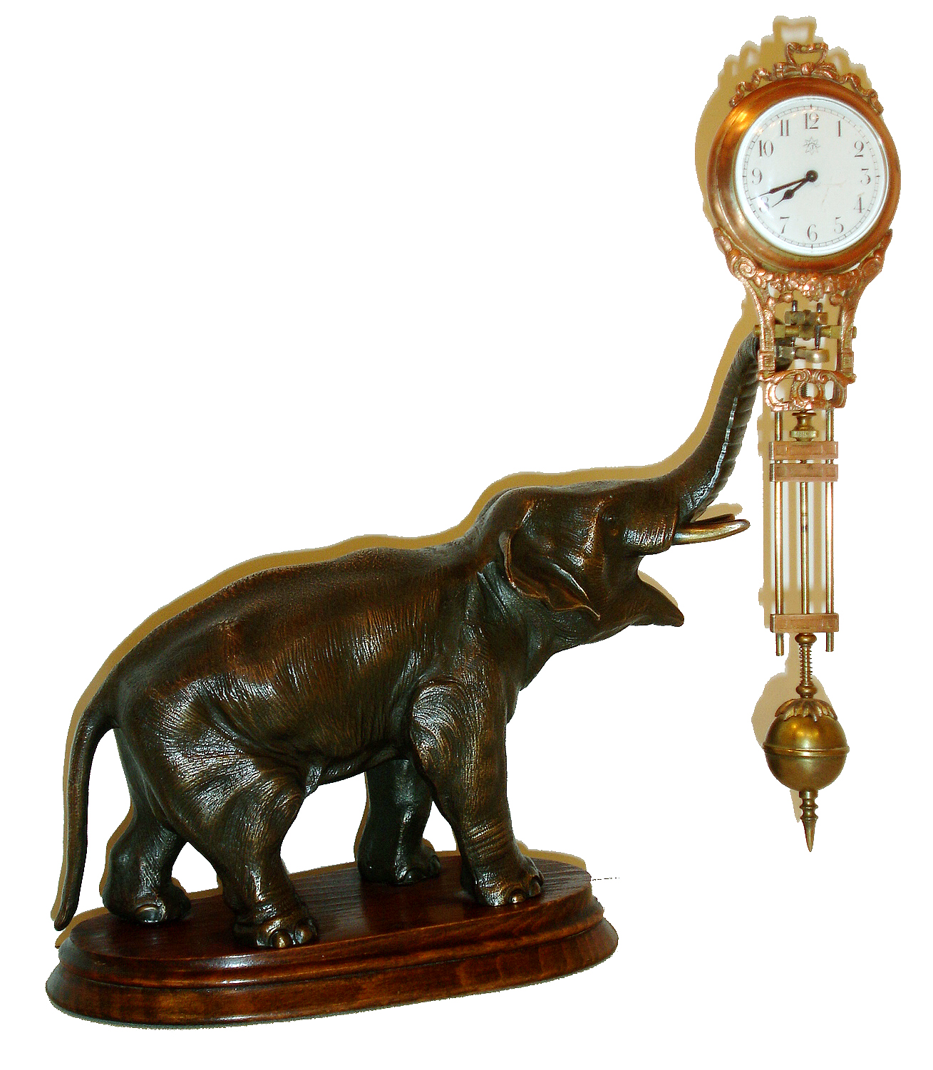Junghans, Germany, "Elephant" model swinger, 8 days, novelty timepiece, the patinated spelter elephant mounted to a molded beech wood base, his trunk supporting clock with compound pendulum, white enamel Arabic numeral dial with Junghans logo, blued steel hands, 8 days, time only movement, signed "Junghans Germany",ca.1920 — Antique Clocks Price Guide