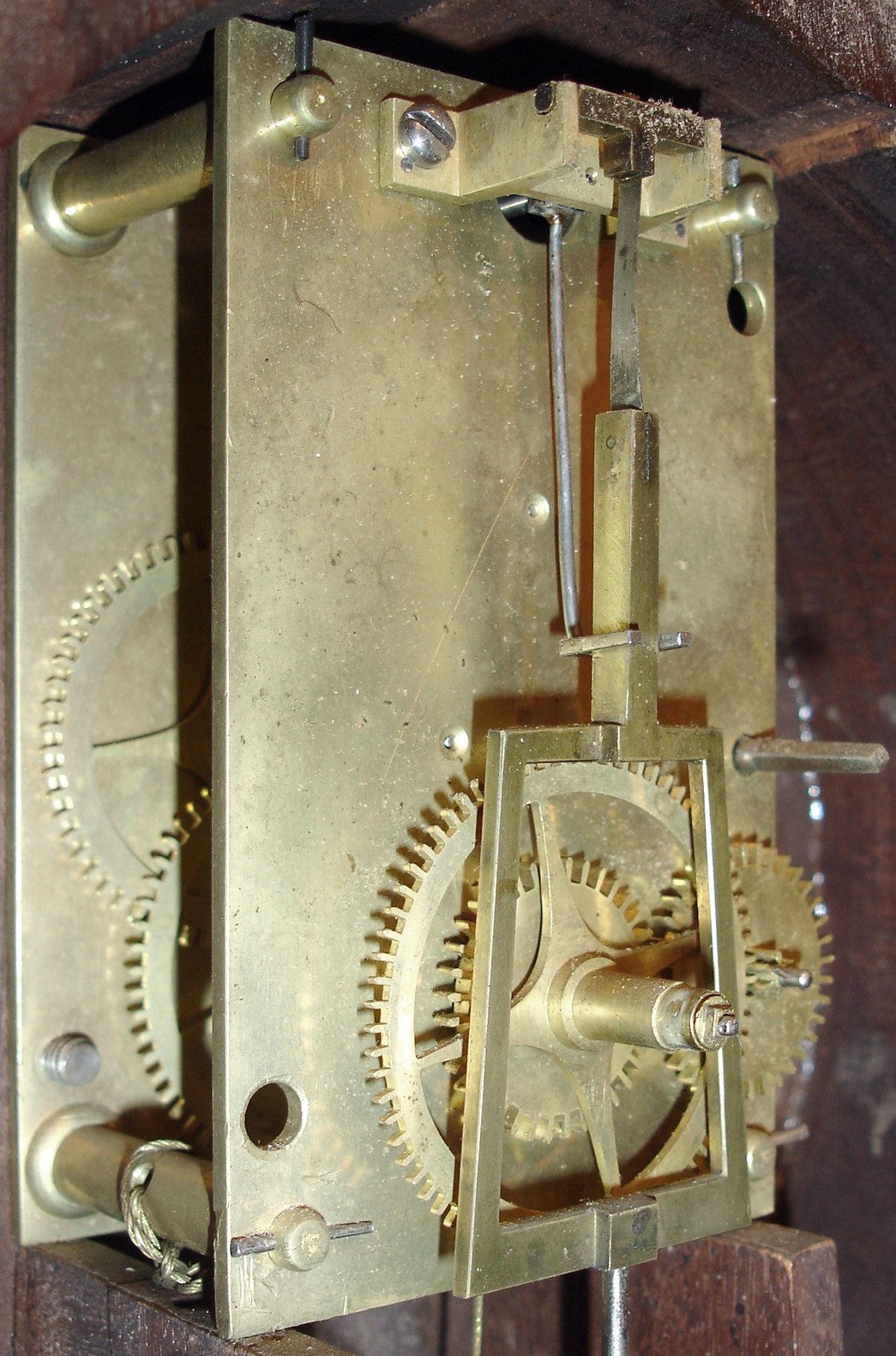 Simon Willard, Roxbury, Mass., 8 days, weight, T-bridge, step train, dead beat escapement brass movement mahogany banded case patent or banjo timepiece, c1805. Throat door held onto the case with four screws. Dial fastened with two L-turns. Rabbeted throat frame. Mahogany backboard. The bottom panel in the base is dovetailed to the sides. A picture of a similar movement with the decorative click is pictured in "Willard's Patent Timepieces" by Paul Foley, pg 22 — Antique Clocks Price Guide