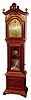Regina Music Box Company, Rahway, NJ, "Regina No. 3 Hall Clock" tall clock with Regina music box, 8 days, time and strike, two brass weight driven movement by Seth Thomas Clock Co. in a mahogany case with barley twist columns flanking hood, shield type carved crest, spherical brass finials and applied carved base with a Regina double comb 15 1/2" disc music box set below pendulum in trunk exposed by glass door. The brass dial has corner spandrels and applied numerals, c1895