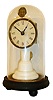 Union Labor Company, Southington, CT, candlestick clock, porcelain column supporting a square plate 30 hours, timepiece with pendulum, pallet arbor with wire and attached caricature of a black man moving from side to side as the clock runs, the lithograph likely cut from a late 19th century trade card, white glossy card stock dial with Roman numerals, spade hands, all on an ebonized base with glass dome, c1865