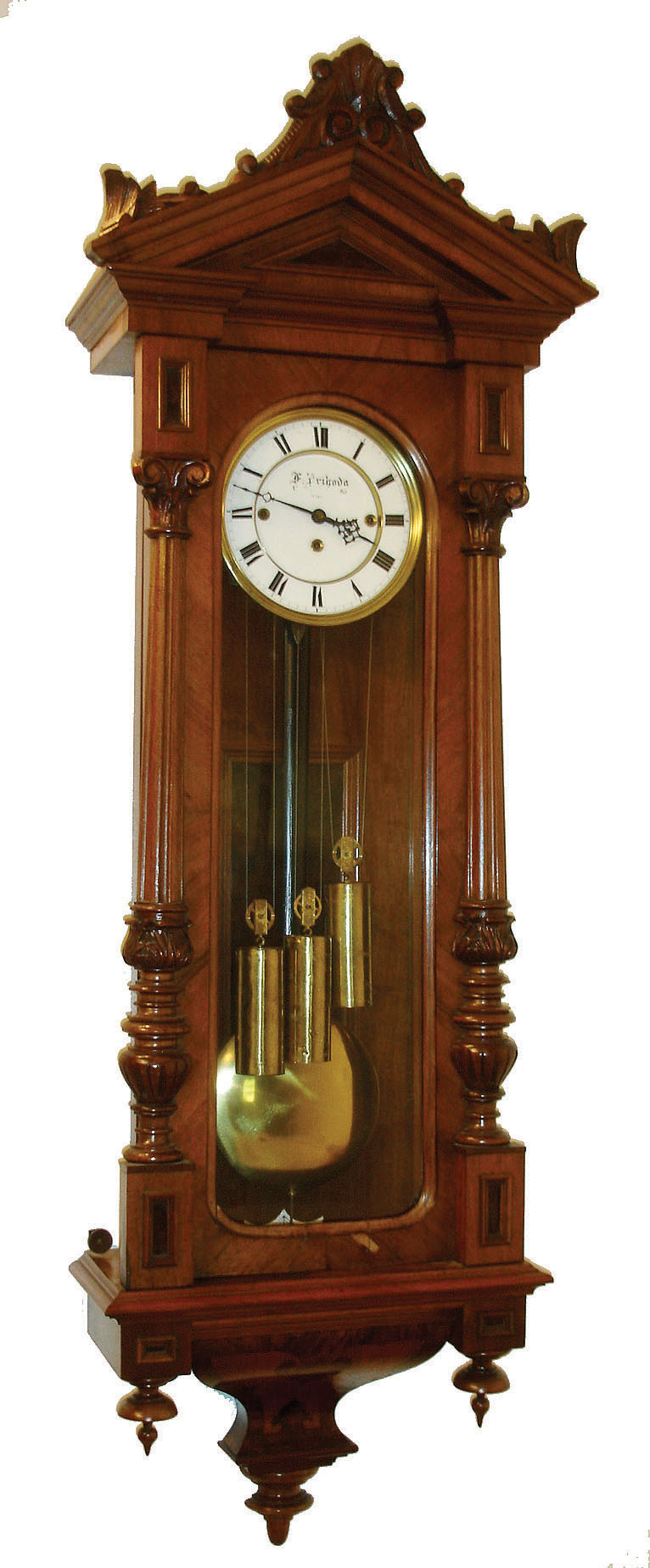 Clocks- 2 (Two): (1) F. Primoda, in Wien, Vienna regulator, walnut and walnut veneered case, split turned columns with carved capitals and bases, deeply curved veneered bottom bracket with inlay, removable carved crest above a molded cornice, signed Roman numeral white enamel dial, pierced blued steel hands, brass 3 train 8 day movement with grand sonnerie striking, ticks and strikes, c1880, and (2) Vienna regulator, ebonized case with turret corners and fluted ornaments, deeply molded door and S curved bottom bracket, Roman numeral white enamel dial, pierced blued steel hands, brass 8 day timepiece movement, polished brass pendulum and weight, c 1870 — Antique Clocks Price Guide