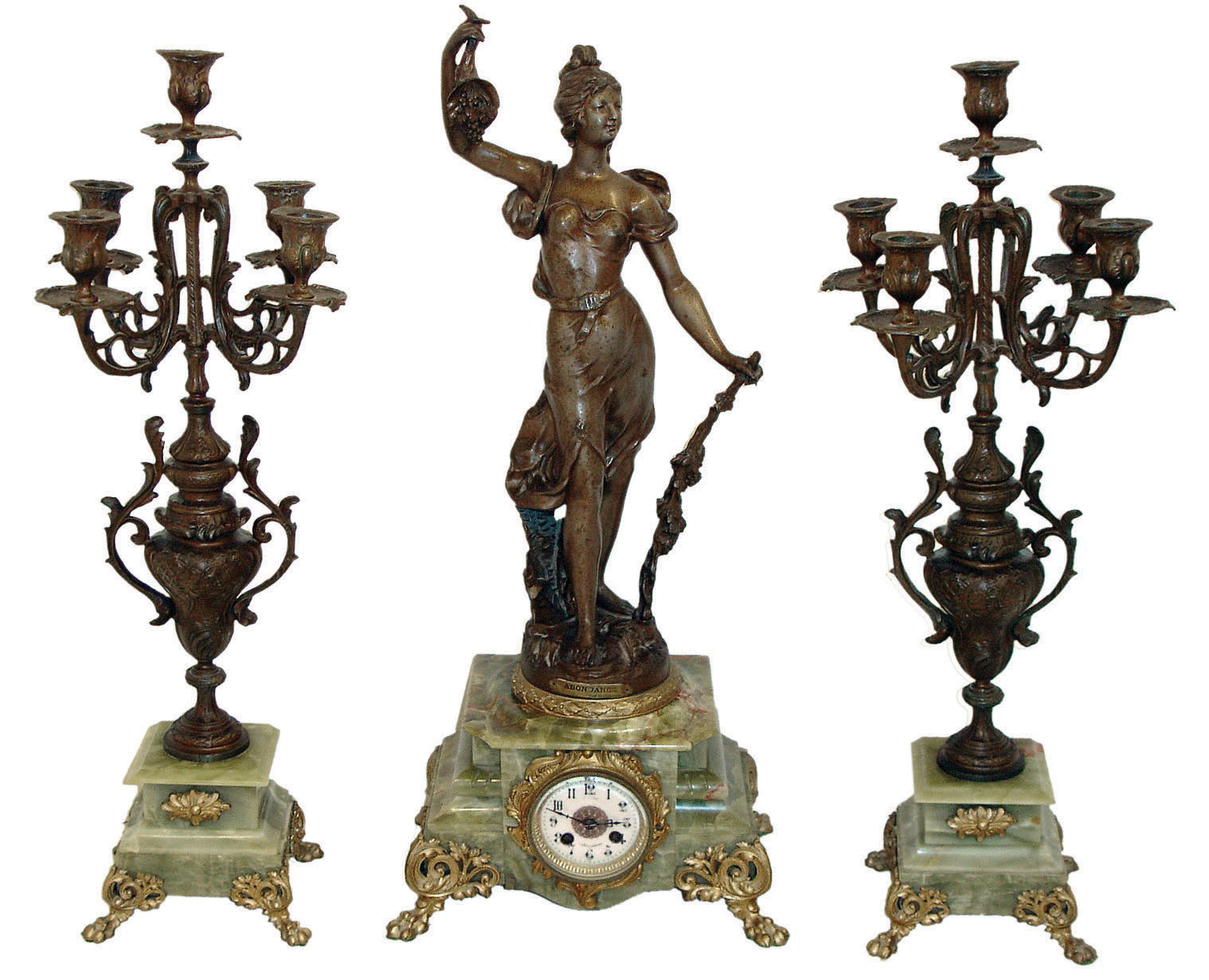 France, large and impressive 3 piece figural mantel garniture, the clock case of green onyx on gilt leaf and scroll ornamented paw feet, gilt dial surround in the rococo style, surmounted by a patinated spelter female figure representing Abundance, the front of the sculpture with applied plaque reading "Abondance par Guillemin", the sculpture also signed "L. Guillemin", gilt bezel with beveled glass, Arabic numeral white enamel dial with illegible signature, blued steel hands, 8 days, time and strike, pendule a Paris movement marked Vincenti, the companion candelabras with patinated surfaces and rocaille ornament, resting on green onyx bases and also with gilt paw feet, c1890 — Antique Clocks Price Guide