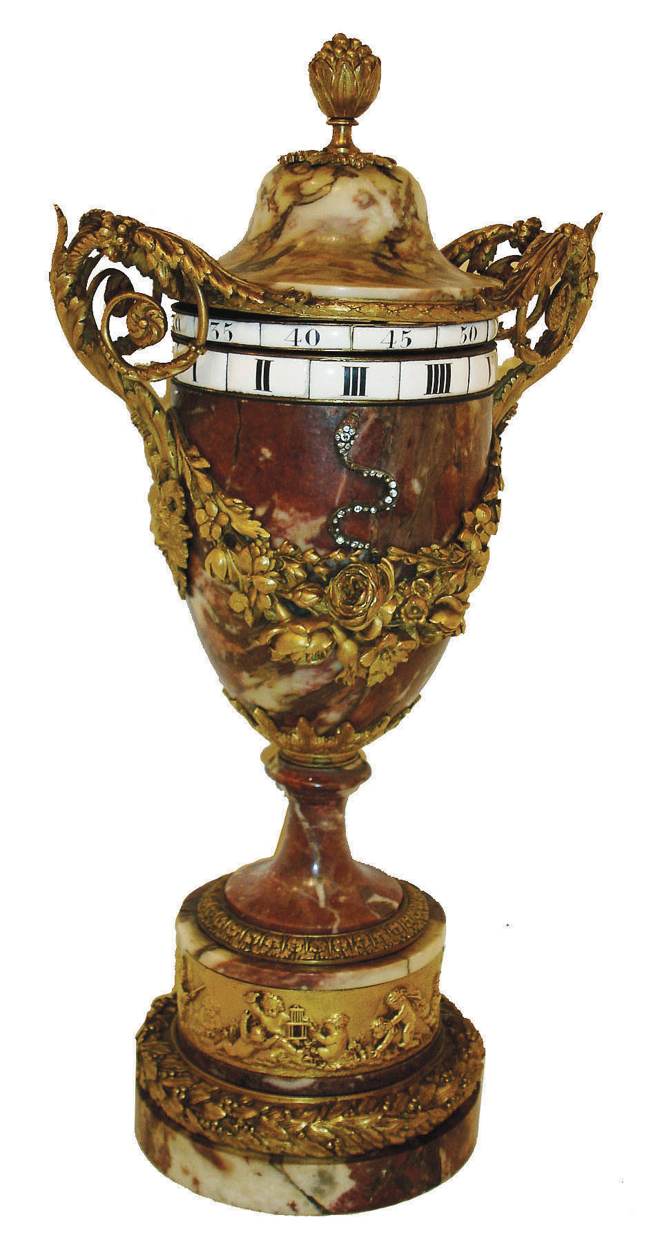 France, orbital or rotary dial clock, in the shape of a large urn, and with a red variegated marble case, the urn, base and cap all cut from the matching stone decorated with bronze trimmings, and with the time indicated via two rotating dials, one for minutes and one for hours, and with a jeweled serpent on the front of the urn, pointing to the current time, c1880 — Antique Clocks Price Guide