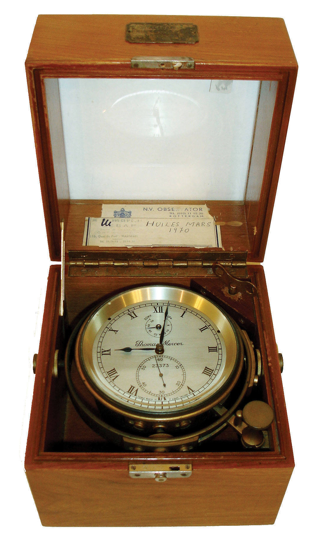 Thomas Mercer, St. Albans, England, two day marine chronometer, decorated brass movement with spring detent escapement and chronometer balance, signed Roman numeral silvered dial with up/ down display, blued steel spade and poker hands, contained in a gimballed brass bowl with spring loaded shutter for access to winding, screw bezel with beveled glass, teakwood interior and exterior protective cases, the inner case with engraved plaque of Alf Lie, watch and chronometer maker and with a small group of service and rate records, serial #23373, c1960 — Antique Clocks Price Guide