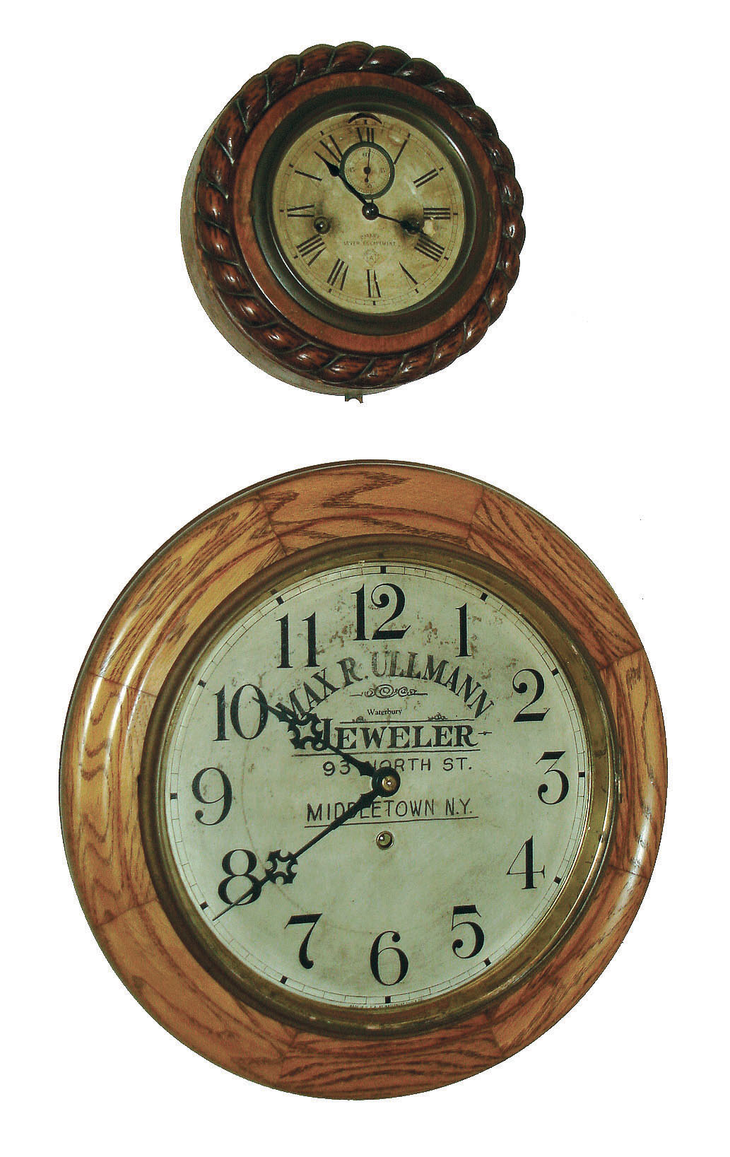 Clocks- 2 (Two) Conn., wall: (1) Waterbury Clock Co., Waterbury, Conn., "Alpha", 8 day spring, pendulum gallery timepiece, c1915 (2) Ansonia Clock Co., New York, "Cable", 8 days, lever movement wall timepiece, c1904 — Antique Clocks Price Guide