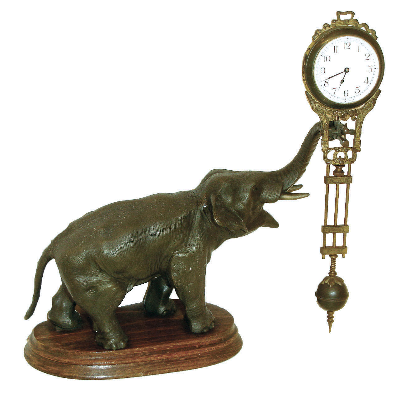 Junghans, Germany, elephant model swinging clock, patinated figure of an elephant mounted to a molded beechwood base, holding the 8 day swinging timepiece aloft at the end of his trunk, clock case with gilt and patinated surfaces, Arabic numeral white enamel dial signed "Junghans Germany" below 6:00, blued steel hands, 8 day time only, movement, c1920 — Antique Clocks Price Guide