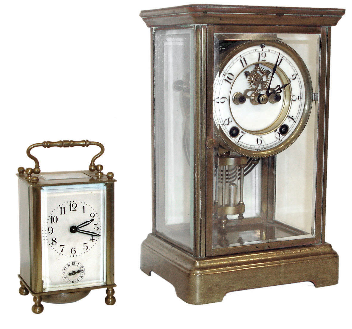 Clocks- 2 (Two).  American crystal regulator, brass case with beveled glass panels, 8 days, time and strike, movement, Arabic numeral white enamel dial with exposed Brocot escapement, faux mercury pendulum, and a French carriage clock, brass case with beveled glass panels, 8 day time and alarm movement, Arabic numeral white enamel dial — Antique Clocks Price Guide