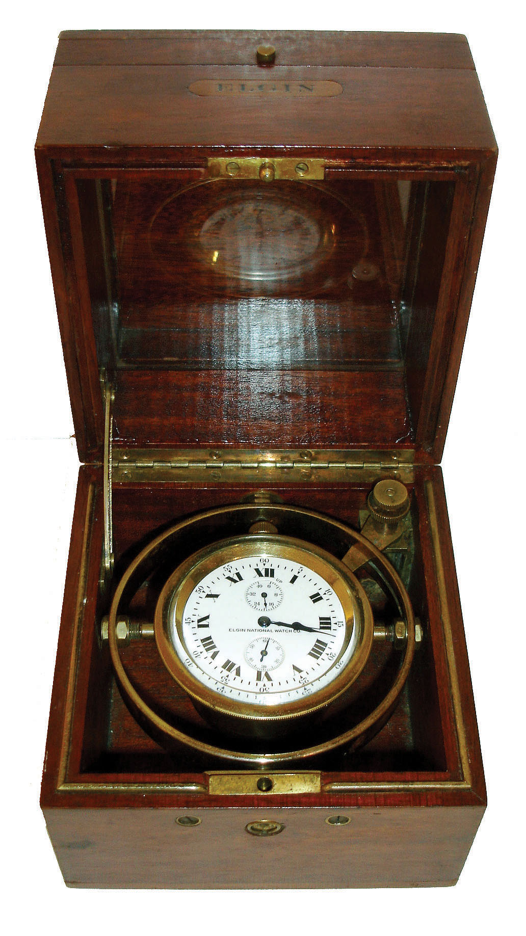 Elgin Watch Co., Elgin, Illinois.  Deck watch, 18 size grade 412, 212 jewel damascened nickel movement with wind indicator, lever escapement with free sprung bimetallic balance, Roman numeral white enamel dial and blued steel hands, contained in a gimbaled brass weighted case, and housed in a chronometer style mahogany box, the top with engraved brass plaque "U.S.S.B. Ship Watch No. 1063" (United States Shipping Board), c1915 — Antique Clocks Price Guide
