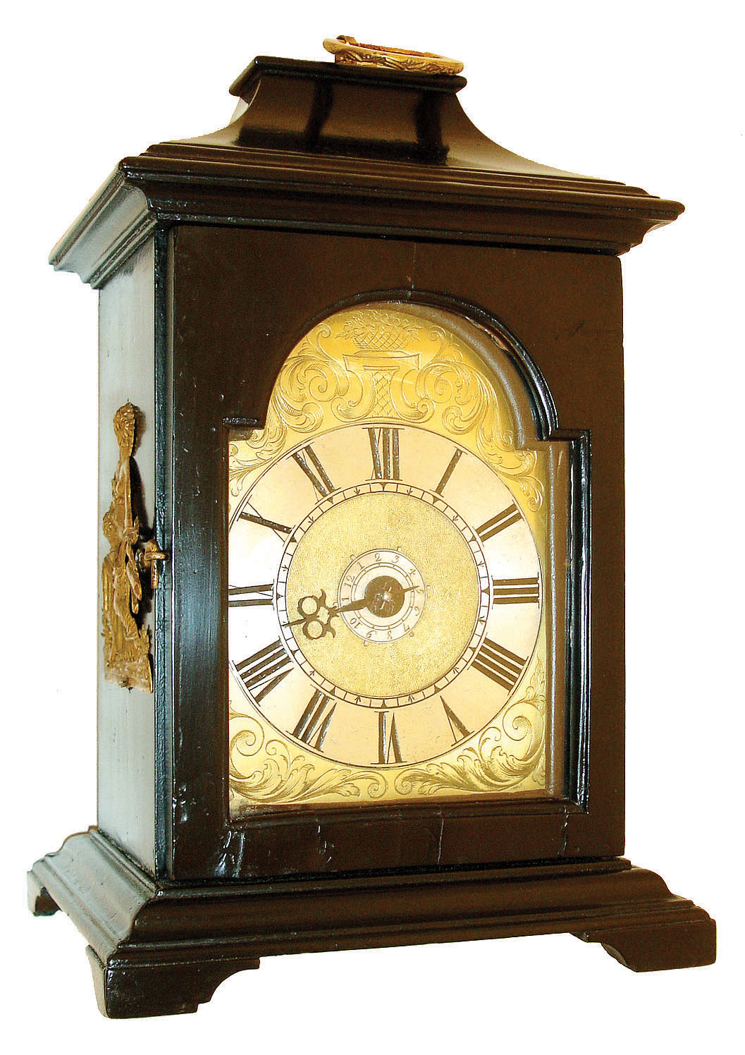 Austria, small bracket clock, ebonized wooden case with ogee molded base and pagoda top with gilt ring carrying handle, case sides with figural gilt mounts, gilt shield shaped dial with engraving, matted center, and Roman numeral applied silvered chapter ring, a single blued steel hand, and silvered alarm set ring, round brass 30 hour fusee timepiece with verge escapement and alarm, turned baluster form pillars, and engraved, watch style back cock and with pendulum fixed to pallet arbor, c1790. — Antique Clocks Price Guide