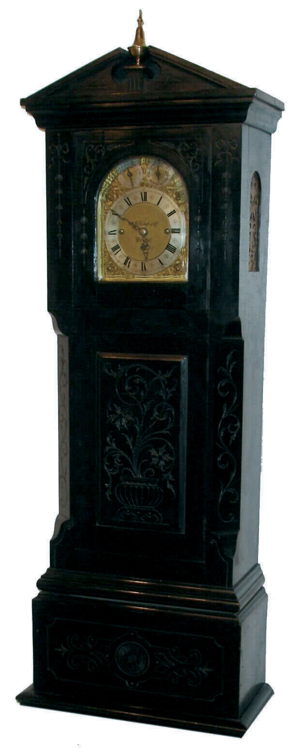 W. W. Kemp & Co., Bristol, England, dwarf tall clock, triple fusee movement, quarter chiming on choice of 8-bells or 5 tubular bells, now in a well constructed case of the same period, with hand carved decorations, c1910 — Antique Clocks Price Guide