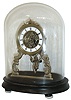 France, 8 day novelty timepiece, Roman numeral white enamel dial with open center, allowing movement to be seen, the case a gilt frame with scroll ornament, pendulum with seated figure, swinging as the clock ticks, mounted to a wooden base, and under a glass dome, c1880