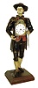 Germany, Black Forest "Uhrentrager" or clock peddler, the figure of polychrome painted sheet iron and in traditional dress, carrying a shield clock at his right fit with a Swiss lever escapement watch movement and dial, and with another clock slung over his back, his left hand clutching three pendulums, all mounted to a chamfered oak base, c1860