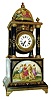 Germany, extremely decorative porcelain and gilt bronze table clock, the portico style case on a square porcelain base with finely painted polychrome enamel panels, depicting figures in classical dress engaged in various activities, cobalt blue columns with gilt ornament supporting the domed porcelain case top with brass finial, also with enamel scenes of figures in a landscape, signed "C. Herbig", the brass spherical clock case suspended below Roman numeral white enamel dial, black painted hands, 8 day timepiece movement with cylinder platform, c1900