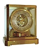 Jaeger - LeCoultre, Switzerland, "Atmos" clock, 15 jewel gilt caliber 529 movement, gilt torsion pendulum, round silvered dial with applied gilt Arabic numerals and arrow markers, gilt hands, all contained in a glazed rectangular case which can be lifted from the base, serial #69998