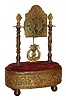 Hamburger, Vienna, Austria, small desk or table clock, 30 hour time only, movement with pin pallet escapement, case draws design inspiration from early 19th century Austrian mantel clocks, shield dial supported by two columns with foliate ornament and flame finials, base with repousse band and mounted to brass feet, music box concealed in the base and activated by pulling a cord at the left, c1900