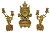 France, for Tiffany & Co., New York, a spectacular 3 piece mantel garniture, the case of urn form supported by two gilt putti, base with foliate decorated toupie feet, and with bound laurel molding, a cast gilt bowknot above dial with suspended floral garlands, and richly ornamented  with very colorful champleve enamel, Arabic numeral gilt dial with champleve center, signed "Tiffany & Co. New York", blued steel hands, brass 8 days, time and strike, movement with lever platform, and also signed "Tiffany & Co. New York", and with a pair of two light candelabra each with a gilt putti, the candle arms with acanthus leaf ornament, and with enamel and feet matching the clock case, c1890