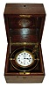 Elgin Watch Co., Elgin, Illinois.  Deck watch, 18 size grade 412, 212 jewel damascened nickel movement with wind indicator, lever escapement with free sprung bimetallic balance, Roman numeral white enamel dial and blued steel hands, contained in a gimbaled brass weighted case, and housed in a chronometer style mahogany box, the top with engraved brass plaque "U.S.S.B. Ship Watch No. 1063" (United States Shipping Board), c1915