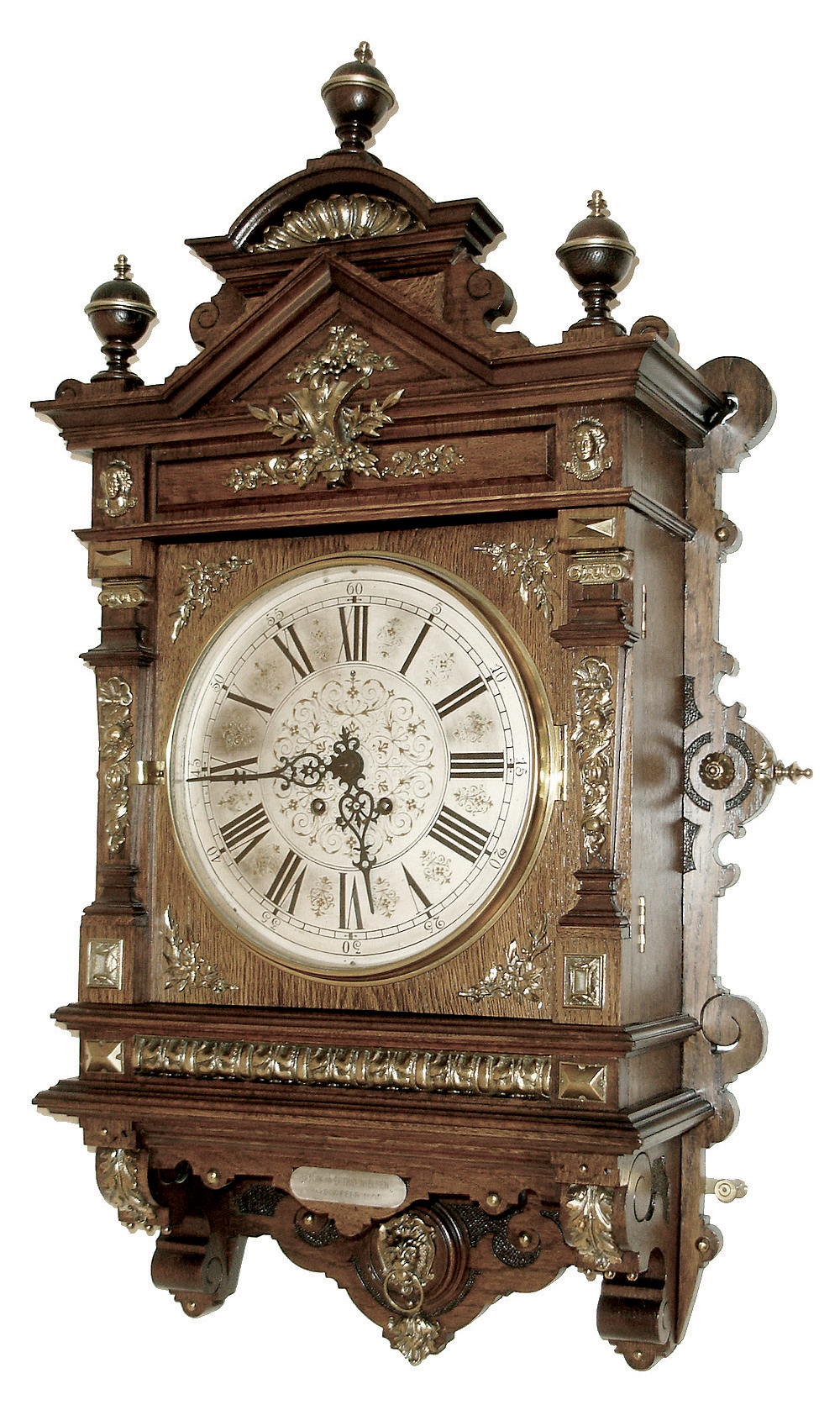Lenzkirch, Germany, ÓGutsherrenuhrÒ oak cased gallery clock with over 40 brass decorations. 8Ó engraved/ etched and silvered dial, with gold accents, 8 days signed movement, serial Nr 1,112,345, the case with profuse trimmings, even the finials with rings of brass, c1896, and then purchased and presented to Ulrik / Estrid Nielsen for 25 years of service 1880 - 1905. — Antique Clocks Price Guide