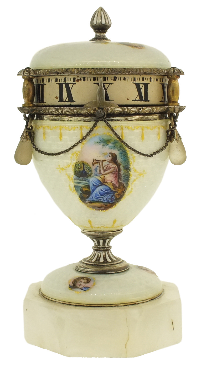 France or Switzerland, miniature urn form annular clock, the silver gilt case with translucent, white guilloche enamel with gilt ornament and 7 polychrome enamel portraits, finial and stem with white enamel accents, silver chain swags with translucent stone teardrop shaped pendant drops below the Roman numeral silvered dial, all on an octagonal, polished stone base, c1900 — Antique Clocks Price Guide