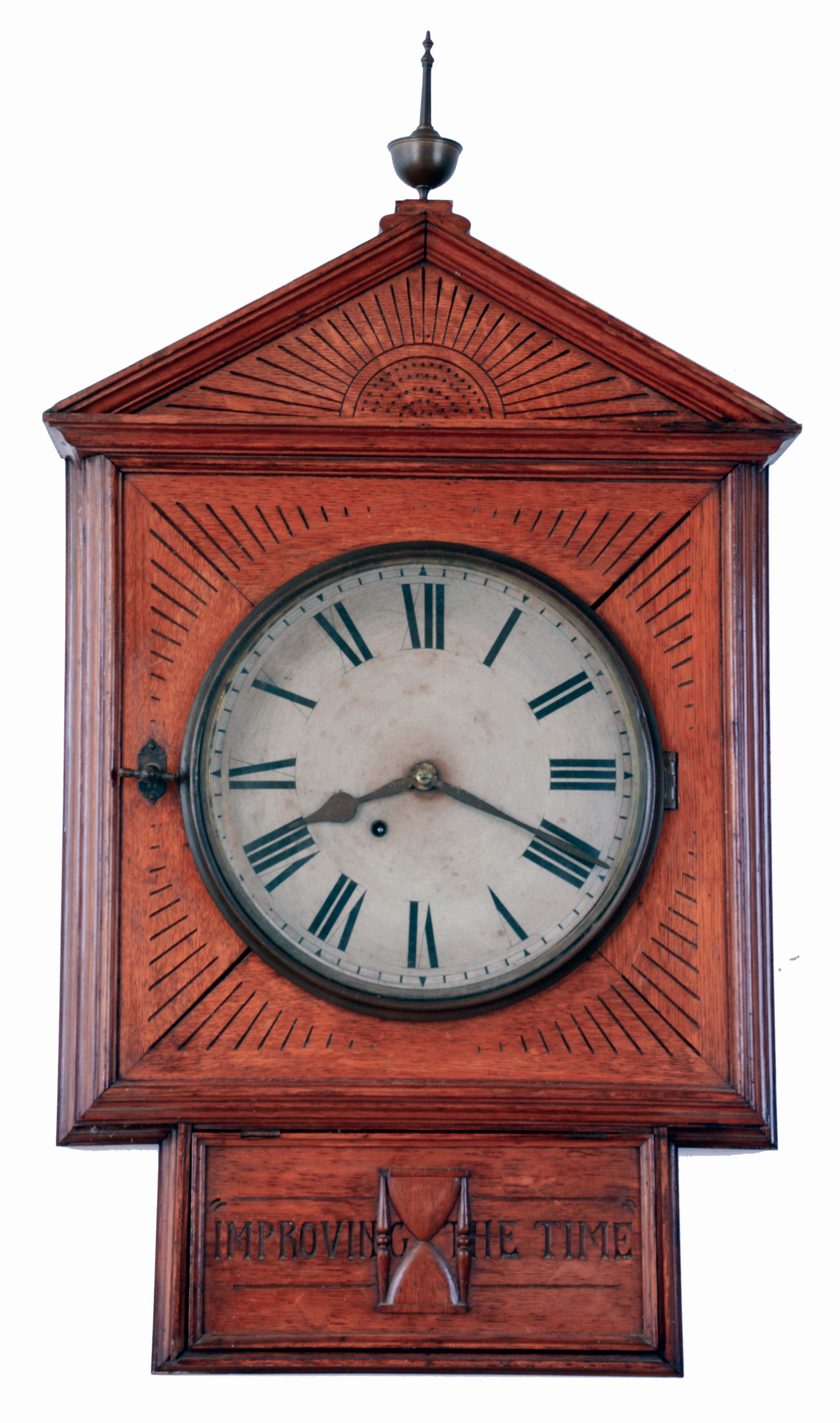 Folk Art wall clock, large, well made oak case with gabled facade, incised line carving, ogee and astragal moldings, and hinged access panel for pendulum with applied, carved hourglass, and also carved "Improving The Time", top with brass finial, Roman numeral paper dial, spade and poker hands, 8 days spring driven, timepiece movement by Ansonia, case dated in pencil on back, 1882 — Antique Clocks Price Guide