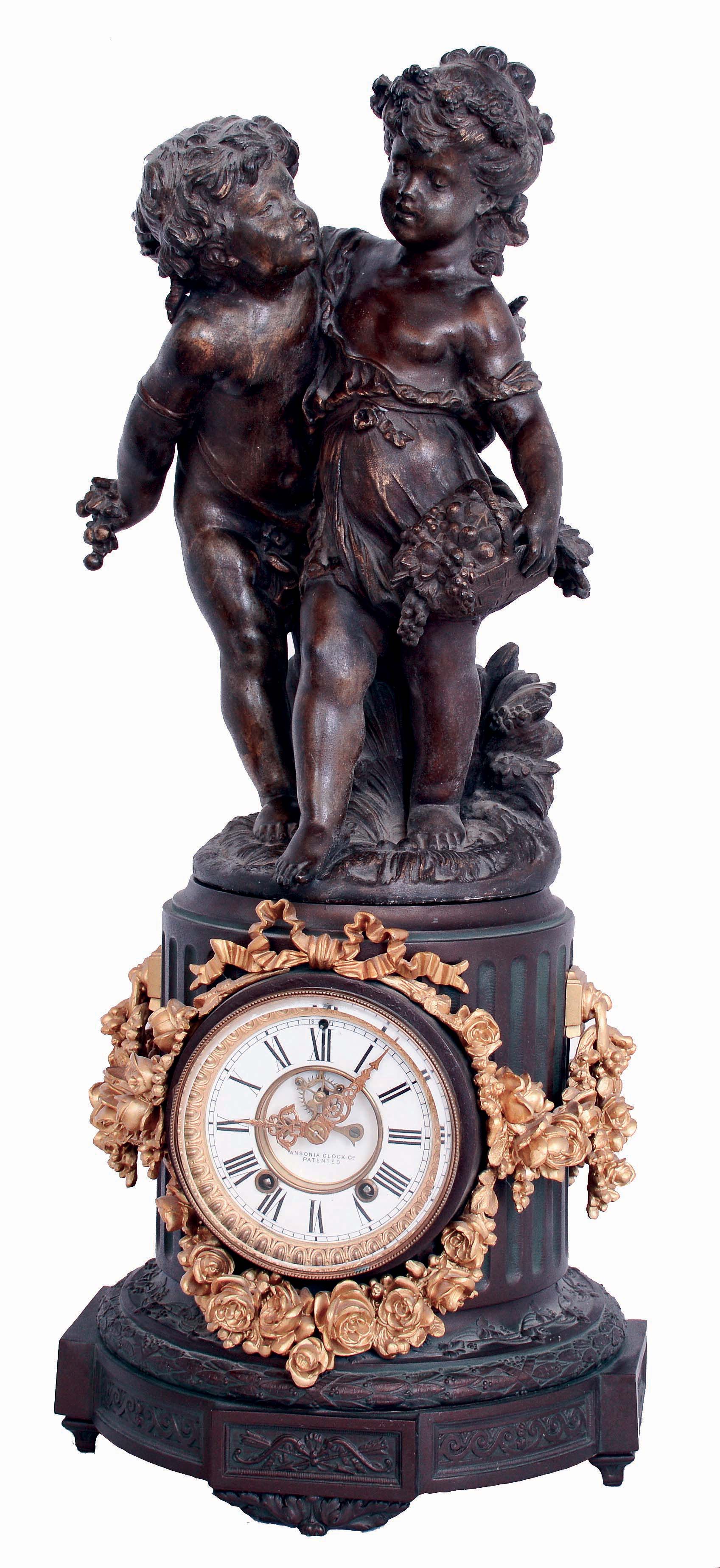 Ansonia Clock Co., New York, NY, "Florida" base with figure "No. 1089", shelf clock, 8 days, time and strike, spring driven movement in a spelter case with gilded floral swags, surmounted by detachable figural spelter putti with a white enamel dial and open escapement, c1900 — Antique Clocks Price Guide