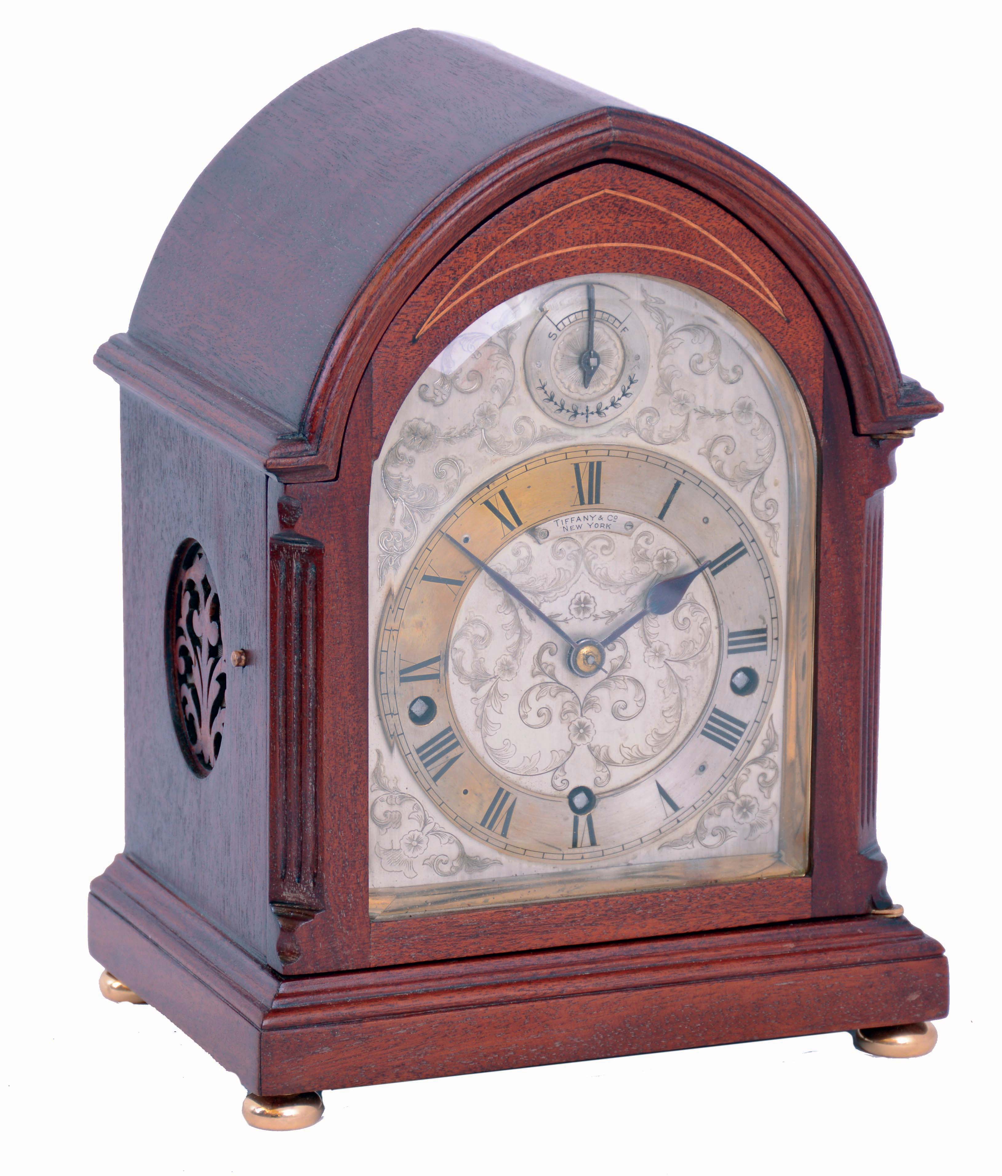 Clocks- 2 (Two) Bracket Chiming: (1) German oak, 8 days, time, strike and Westminster chime round top bracket clock, with subsidiary indicators for chime/silent and fast/slow adjustment, c1910 (2) J.J. Elliott, for Tiffany & Co., New York, mahogany, 8 days, balance wheel bracket clock with Westminster chimes on coiled gongs, c1910 — Antique Clocks Price Guide