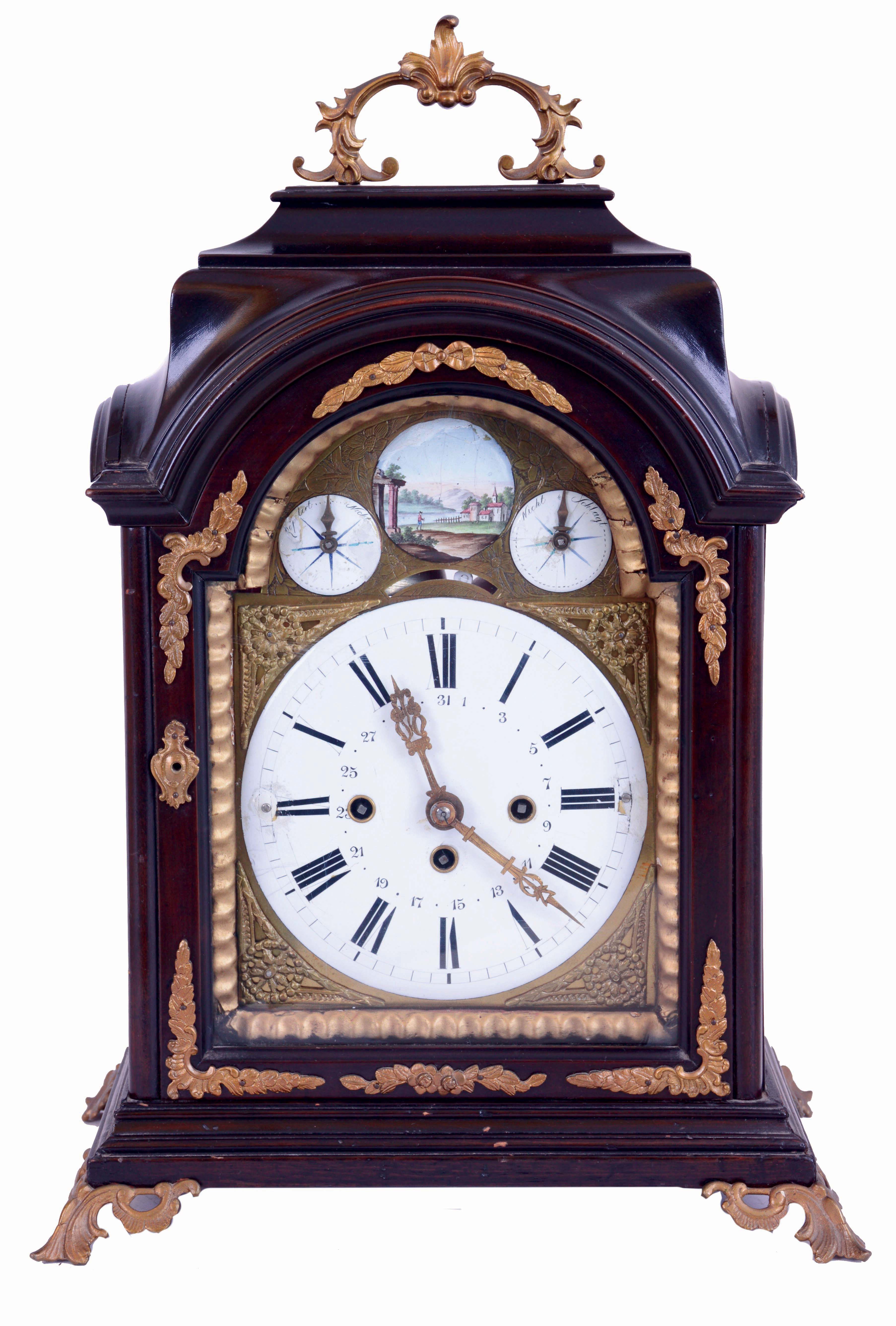 Austria, bracket clock, ebonized case with molded break arch top, molded base, cast brass feet and carrying handle, sheet brass dial with mock pendulum, gilt spandrels, Roman numeral white enamel dial, the arch with controls for the striking, and with landscape painting on enamel, pierced and engraved brass hands, case with glazed sides, and Helios mask frets, three train, quarter striking movement with verge escapement, strike trains with going barrels, time train with fusee, c1800 — Antique Clocks Price Guide
