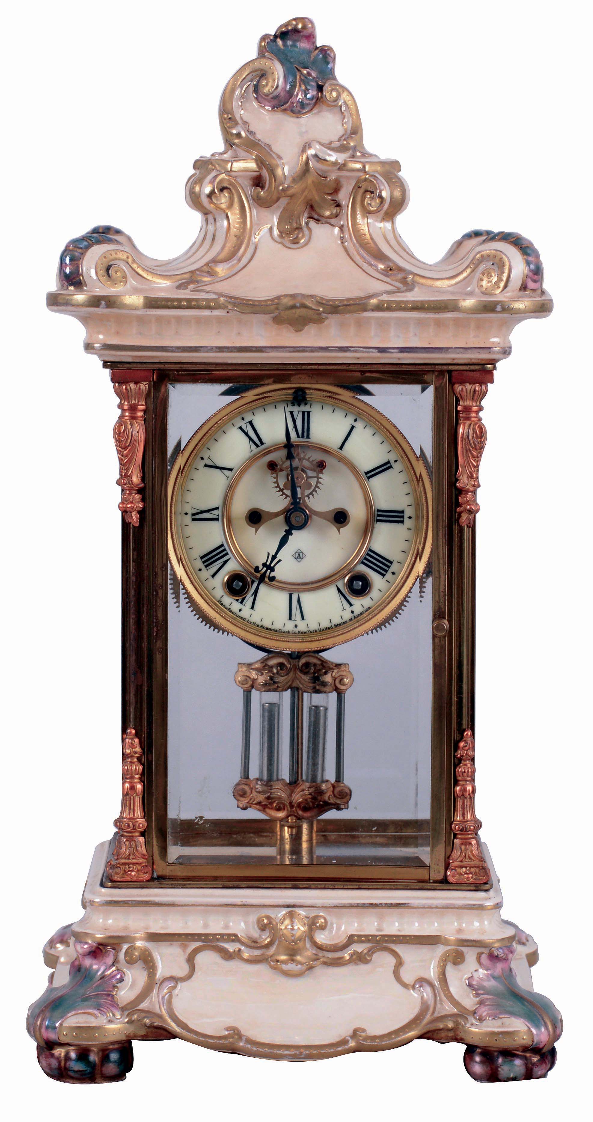 Ansonia Clock Co., New York, NY, "Crystal Regulator No. 5" in a gilt and brass case with a Royal Bonn top and base and a spring driven, 8 days, time and hour/half-hour strike movement with a visible escapement, c1906. — Antique Clocks Price Guide