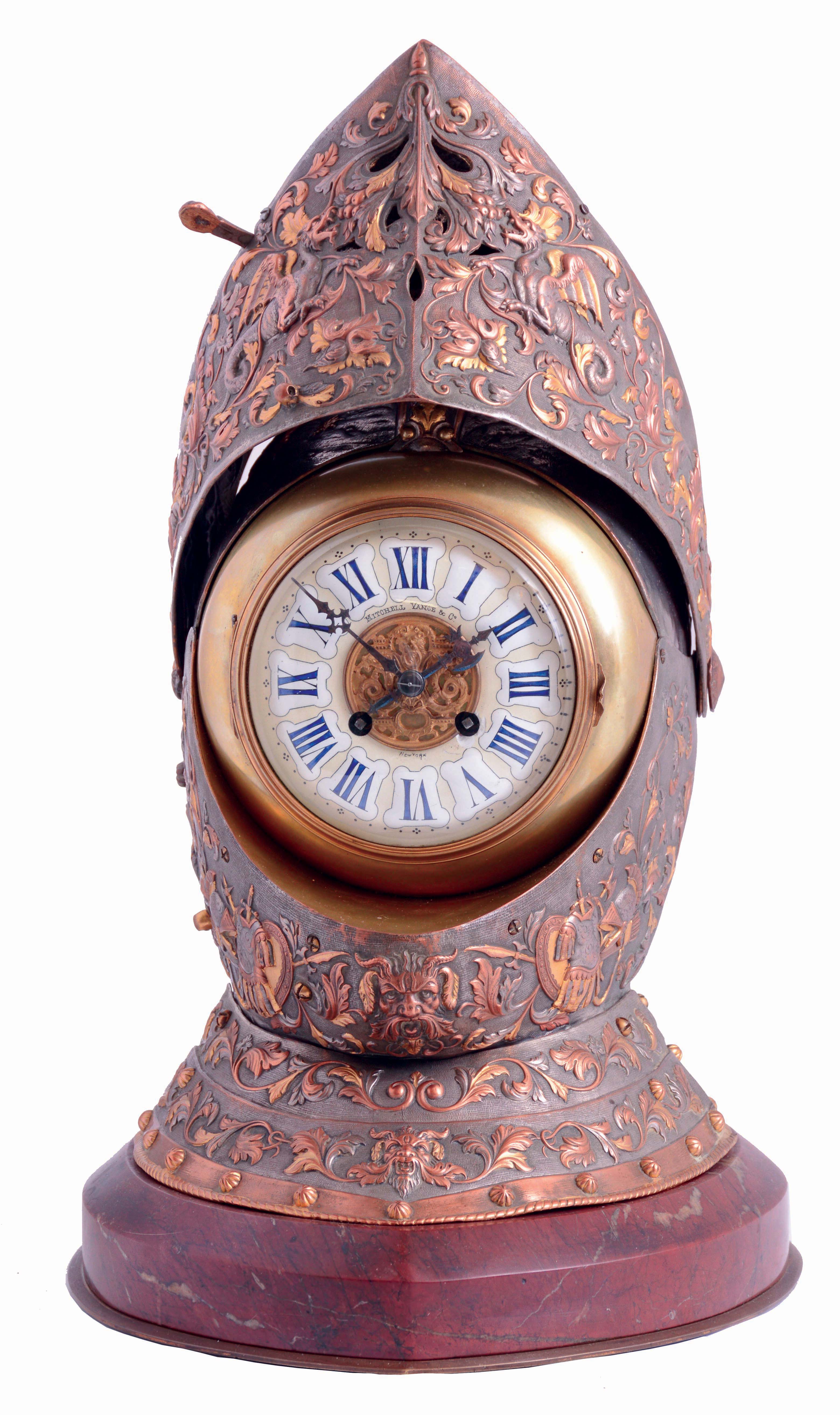 France, for Mitchell, Vance and Co., New York, a spectacular table clock in the form of a knights helmet, constructed of sheet copper, the chased ground finished in patinated silver, and festooned with repousse ornament, the decoration consisting of trailing vines and leaves, satyr masks, dragons, armorial trophies, and each side with a scene probably depicting Richard II meeting with the rebels during the Peasants Revolt of 1381, the various forms further enhanced by the application of gold, the visor opening to reveal a clock, with Roman numeral cartouches on a pale yellow enamel ground, blued steel hands, the hour in the form of a battle axe, and 8 days, time and strike movement with lever platform, striking on a coiled gong, all resting on a conforming, brass trimmed griotte marble base, c1890 — Antique Clocks Price Guide