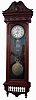 Jewelers hanging regulator, large custom made cherry case with glazed front and sides, molded cornice and scroll carved, oak leaf and acorn decorated top above a frieze with applied turned and carved ornament, the case bottom with leaf carved corbels flanking a balustrade with scroll and scallop carved drop, Roman numeral paper dial marked "H.J. Hoffman Jeweler Loogootee Indiana", blued steel Breguet style hands and with center seconds hand, Swiss weight driven, 8 day timepiece movement with pinwheel escapement, brass clad weight, gridiron pendulum with lyre ornament and large brass clad ball, interior of case with a photo of the shop of J. Meyer Jeweler, Loogootee, Indiana, and also his trade card, c1880