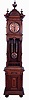 Furtwangler, L. & Sohne, Furtwangen, Germany, open well tall clock, 8 days, time and strike, on gong, brass weight driven movement in a carved walnut case on bun feet with large turned finials and copper finished brass dial. The dial, pendulum bob and weights are matching filigreed copper tone, serial #13235