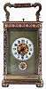 France, carriage clock, gilt brass case with applied foliate ornament, and five beveled glass panels, Arabic numeral white enamel alarm and time dials, each with gilt, ornamental center, and with a matte gilt mask, fancy blued steel hands, 8 days, time and strike movement with lever platform, announcing the hours and half hour on a coiled gong, and repeating the last hour on demand, c1900