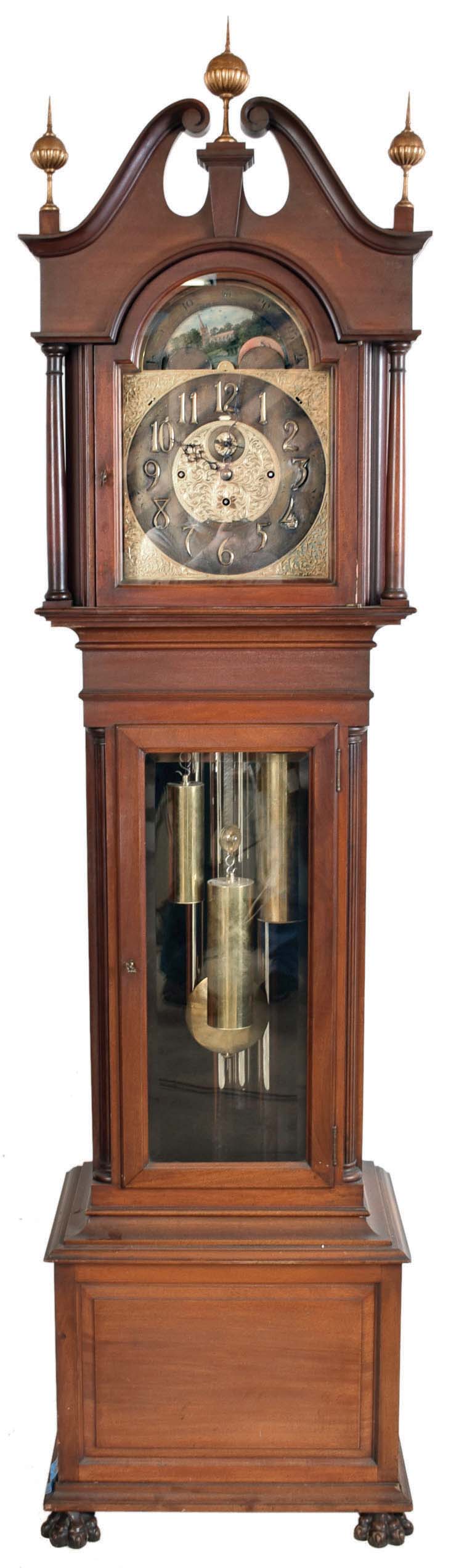John J. Elliott, London, England for Schreve, Crump & Low Co., Boston, Mass., tall clock, 8 day, time, strike and Westminster chime on 5 signed Harrington tubes, three train brass weight driven movement in a mahogany case with full columns flanking broken arch hood with gilded wooden ball and spire finials, beveled glass in trunk door and front paw feet. The brass dial has pierced brass corner spandrels and dial center, silvered chapter ring with applied brass numerals, hour strike / silent and Westminster / silent selectors and moon phase dial — Antique Clocks Price Guide