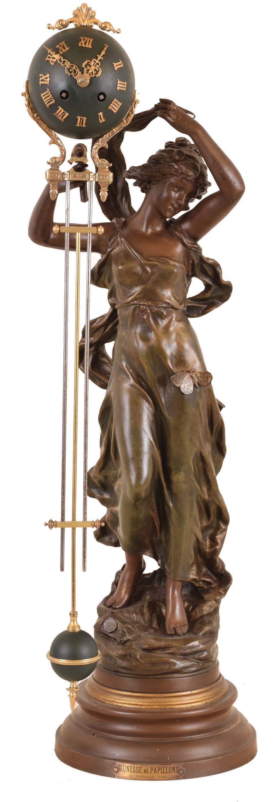 France, swinging clock, "Jeunesse et Papillons" (youth and butterflies) by Rancoulet, the female figure in flowing garb and with a butterfly on her dress, her right arm held aloft, and supporting the swinging timepiece, the 8 daytime and strike movement contained in the patinated, upper sphere, with three rod gridiron style connection to matching lower ball, alll mounted to a painted, molded base — Antique Clocks Price Guide