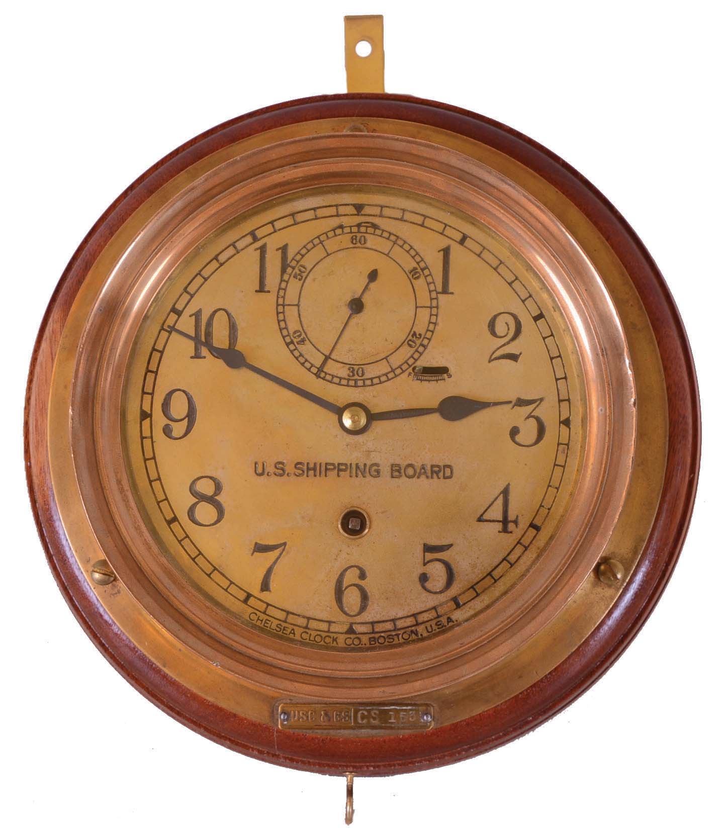 Chelsea Clock Co., Boston, Mass., 8 days, spring brass lever movement ward or engine room time piece. Serial No. 128125. Engraved on the dial: "U.S. Shipping Board". There is a tag on the case that reads: "USC & GS CS 153". The US Shipping board was established in 1916 to address the eroding position of U.S. Shipping. It lasted until 1934 to be taken over by other government agencies — Antique Clocks Price Guide