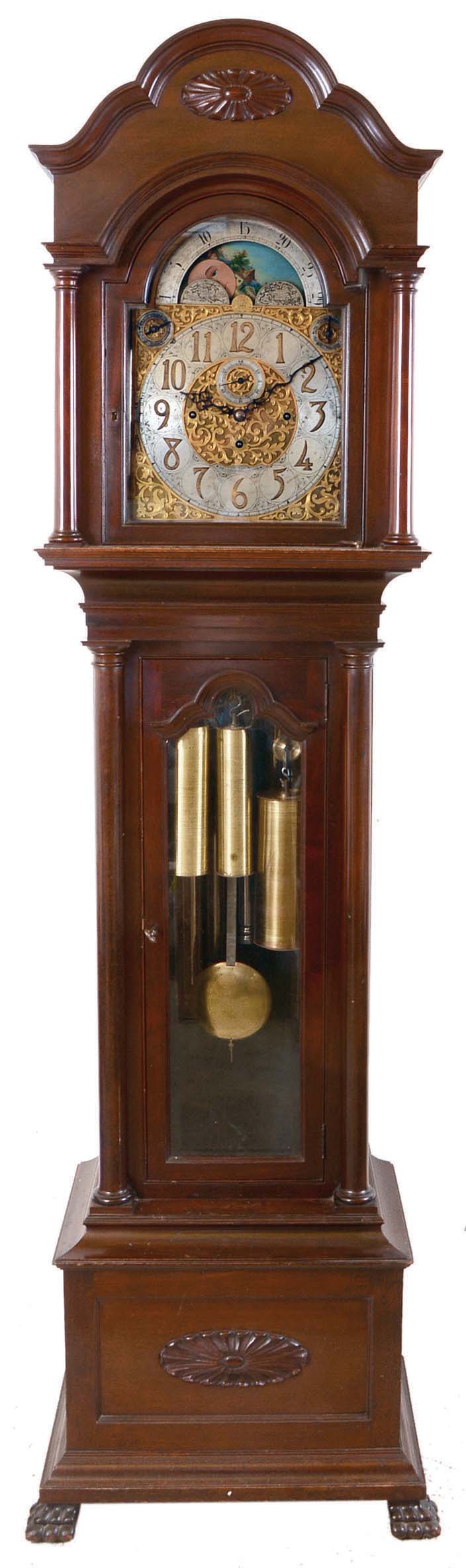 Herchede Clock Co., Cincinnati, Ohio, tall clock, retailed by Wm. J. Davis, Philadelphia, 8 days, time, strike and chime playing Westminster or Whittington on 9 marked Herschede Crown Symphony tubes, three brass weight driven, Germany stamped movement in a mahogany case with full columns flanking dial, beveled lower glass, paw feet and sunburst on base and hood. The brass dial has silvered chapter ring, second's bit, tune selector and strike / silent selection, applied cast and engraved dial center and spandrels and moon phase. — Antique Clocks Price Guide