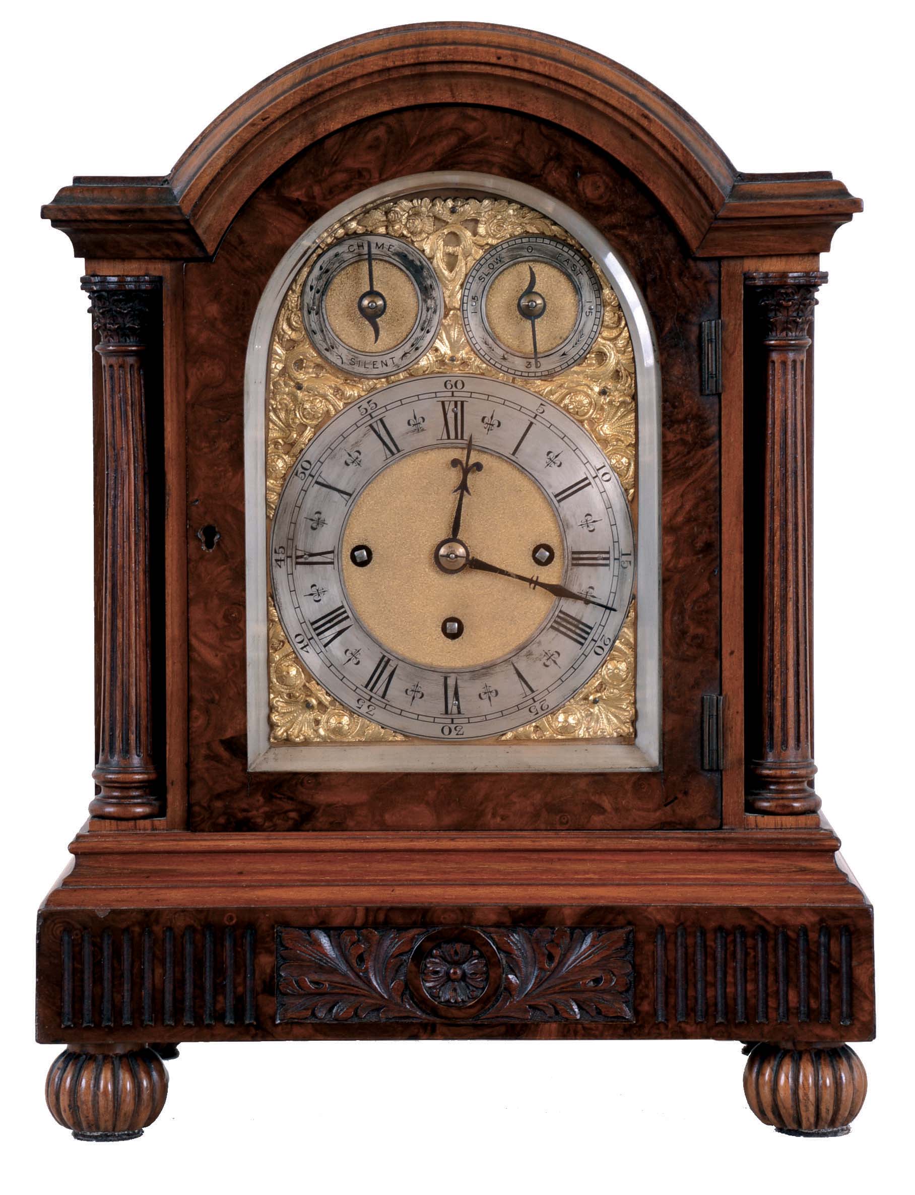 Germany, Westminster chime bracket clock, the walnut and burl walnut veneer case with molded, carved base, arched top, corinthian columns, and reeded ball feet, the sides with pierced wooden frets, composite dial with gilt spandrels, silvered chapter ring and chime control dials, with matted ground, blued steel hands, large 8 day, three train fusee movement, sounding the quarters on 4 gongs, and the hour on a larger gong — Antique Clocks Price Guide