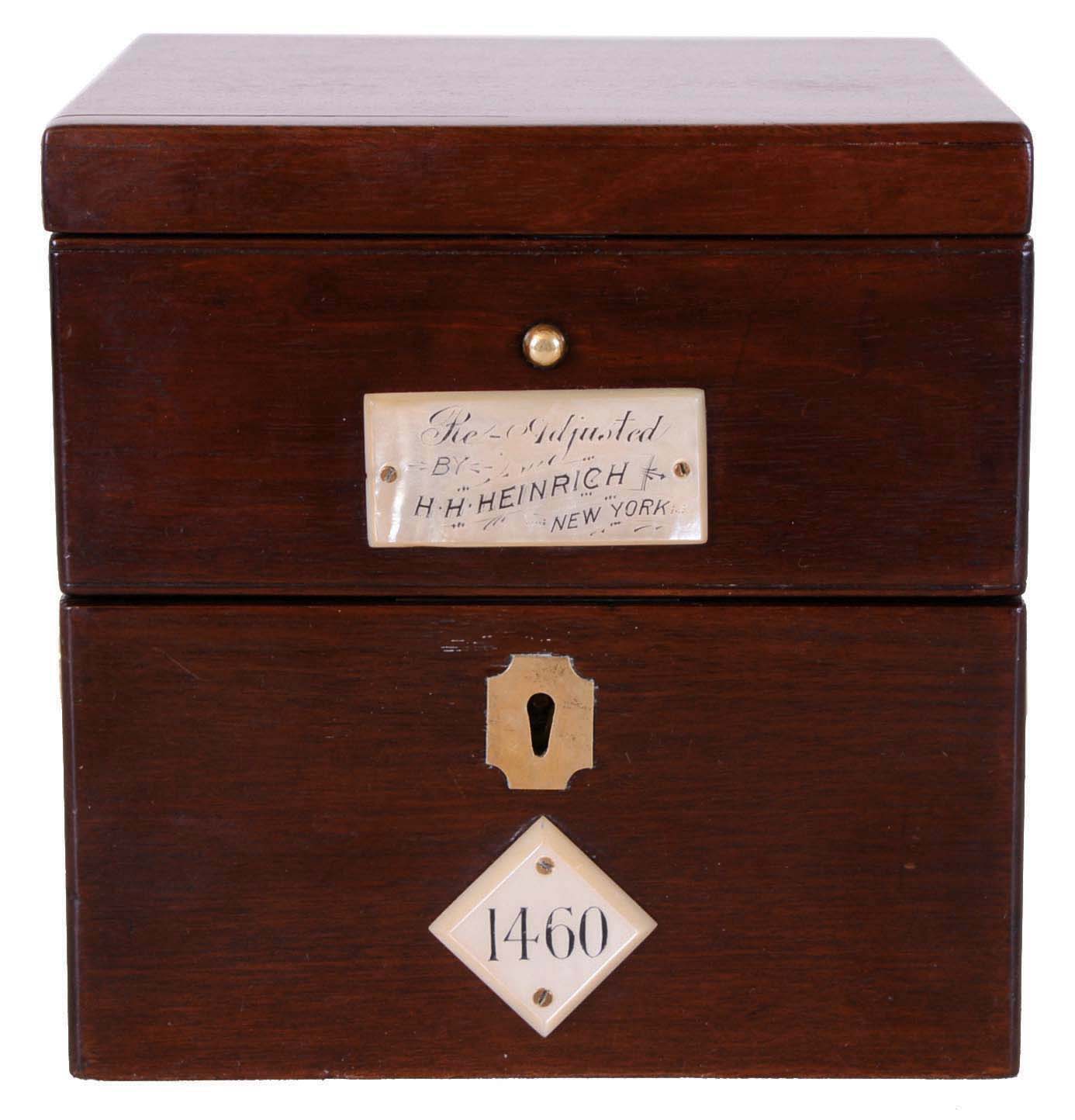 Parkinson & Frodsham, Change Alley, London, 2 day marine chronometer, small gilt plate fusee movement with spotting, spring detent escapement, and chronometer balance with blued steel helical hairspring, silvered Roman numeral dial with wind indicator, blued steel spade and poker hands, screw bezel with flat beveled glass, lacquered brass tub in gimbals, with inner shock proof tub containing movement, all in a mahogany box with brass hardware, the front with mother of pearl plaques, one marked "Re Adjusted by H. H. Heinrich New York", the other with the chronometer number "1460",with original numbered winding key, 6 1/2" x 6 1/2" x 6 1/2", c 1825 — Antique Clocks Price Guide