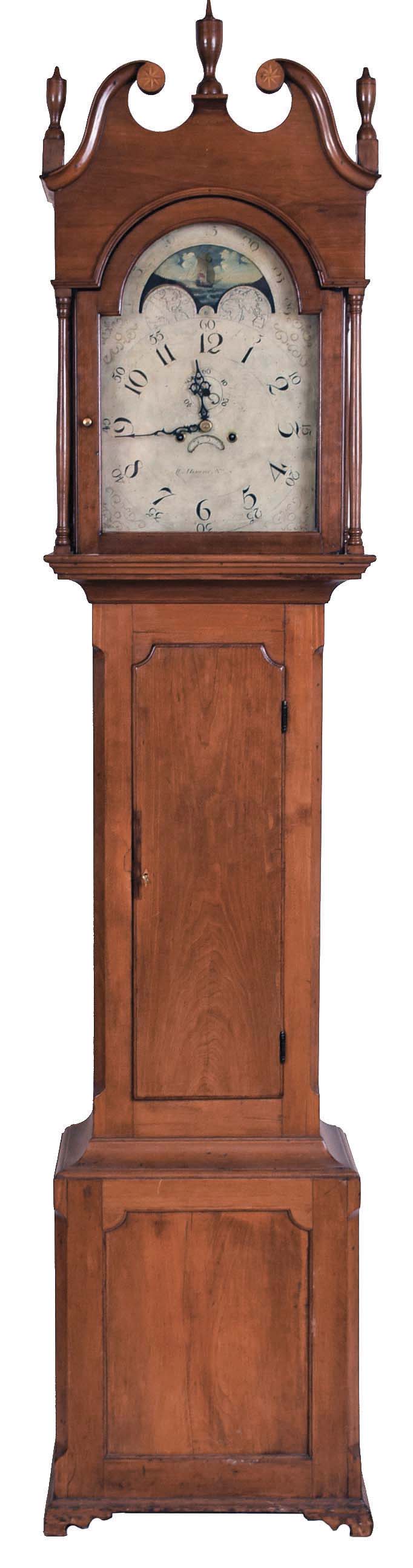 William Herwick (Sr.) , Greensburg, Penn., "No. 6" tall case clock, 8 day, time and strike, weight driven movement in a cherry case with broken arch top, three turned wooden finials, star inlaid rosettes and four full columns flanking hood, bracket base with recessed panel. The painted metal dial with maker's signature has date calendar and moon phase. The dial's false plate is signed "PATTON & JONES PHILA". — Antique Clocks Price Guide