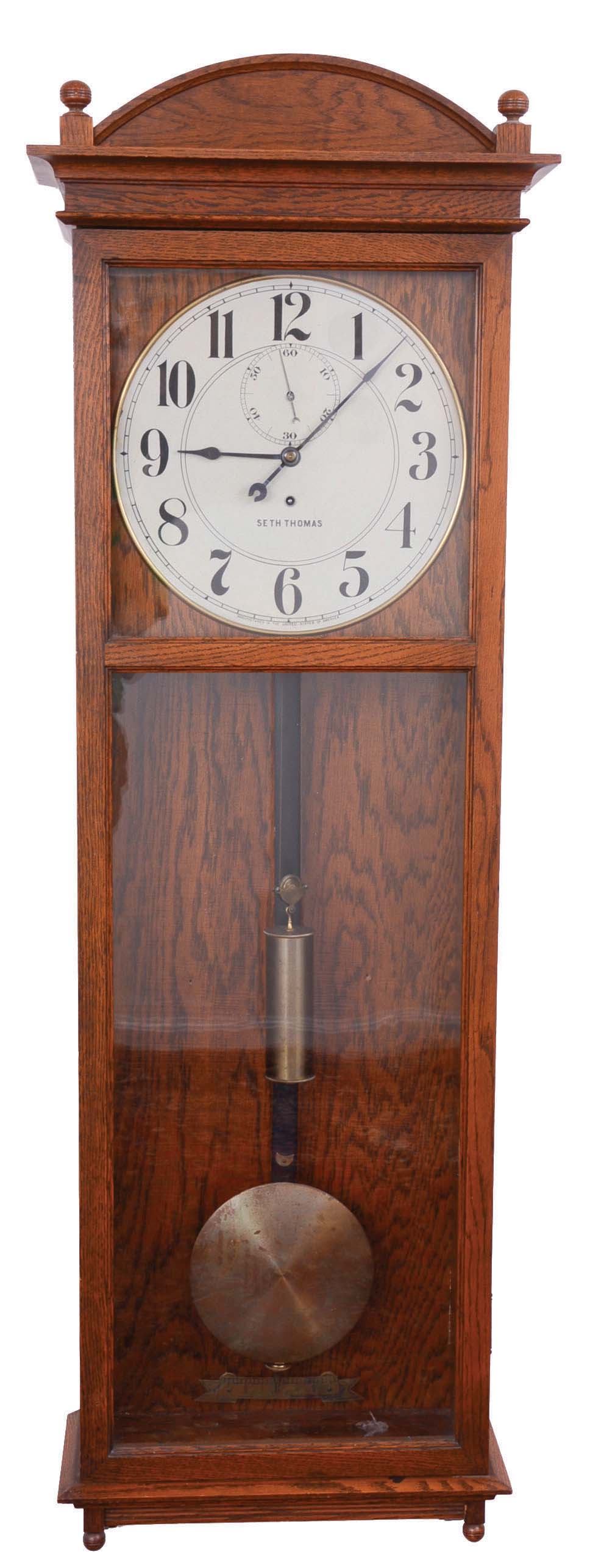 Seth Thomas Clock Co., Thomaston, Conn., "Regulator No. 20", jeweler's regulator wall clock, 8 day, time only, brass weight driven movement in an oak case with a painted metal dial — Antique Clocks Price Guide