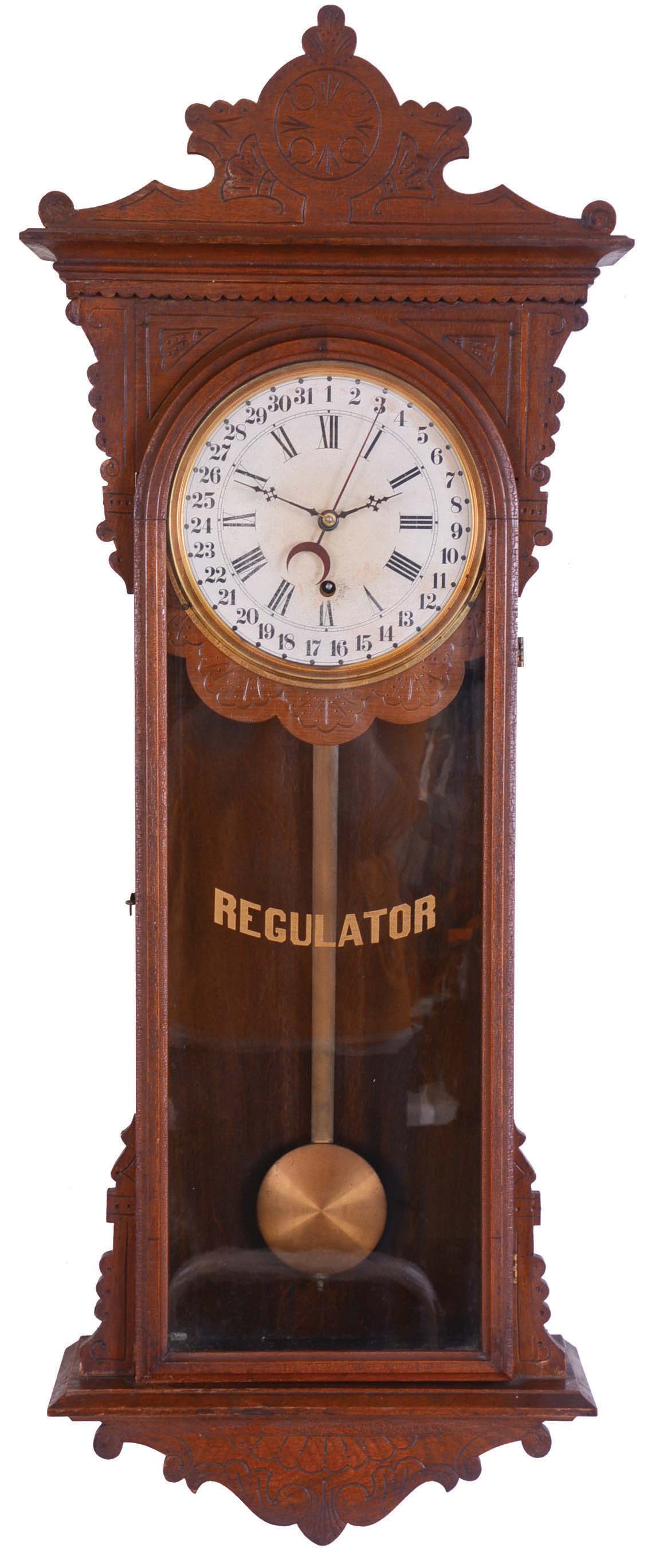 E. N. Welch Mfg. Co., Forestville, Conn., "Sembrich" wall hanging clock with a spring driven 8 day timepiece movement with a simple calendar mechanism in a black walnut case. — Antique Clocks Price Guide
