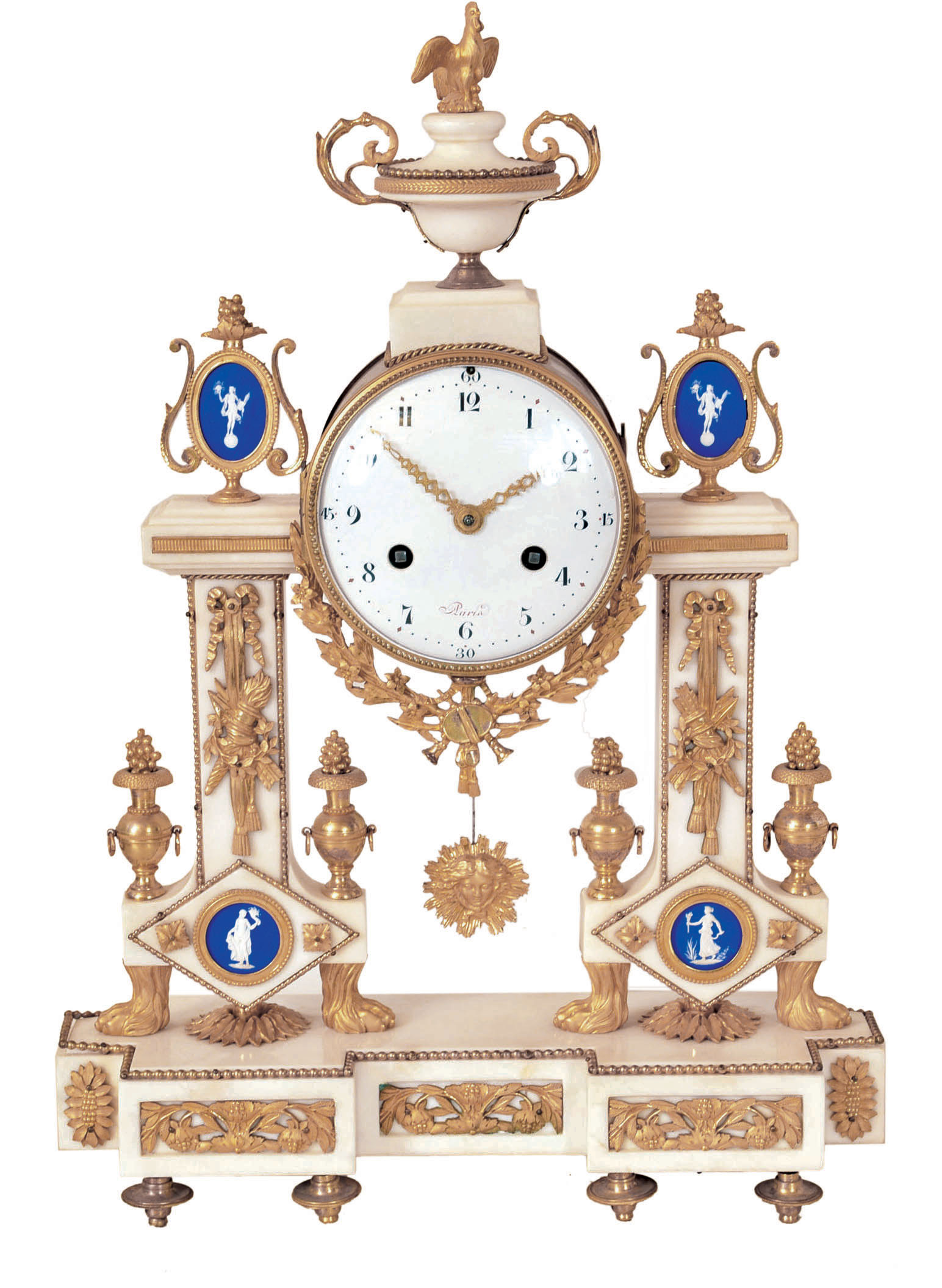 France, Louis XVI mantel clock, the white marble case with applied gilt bronze neoclassical ornament, the columns with bowknot suspended trophies, with flanking urns, and with gilt paw feet, and set with a gilt framed, blue jasper Wedgwood style plaque, the base with three panels with inset ornament, and resting on six toupie feet, the clock housed within a gilt cylinder with gilt bezel and convex glass, with flanking, oval framed blue jasper plaques, and surmounted by an urn, with crowing cock, Arabic numeral whie enamel dial, pierced, engraved gilt hands, 8 day time and strike pendule a Paris movement, and silk thread suspended pendulum with gilt Helios mask — Antique Clocks Price Guide