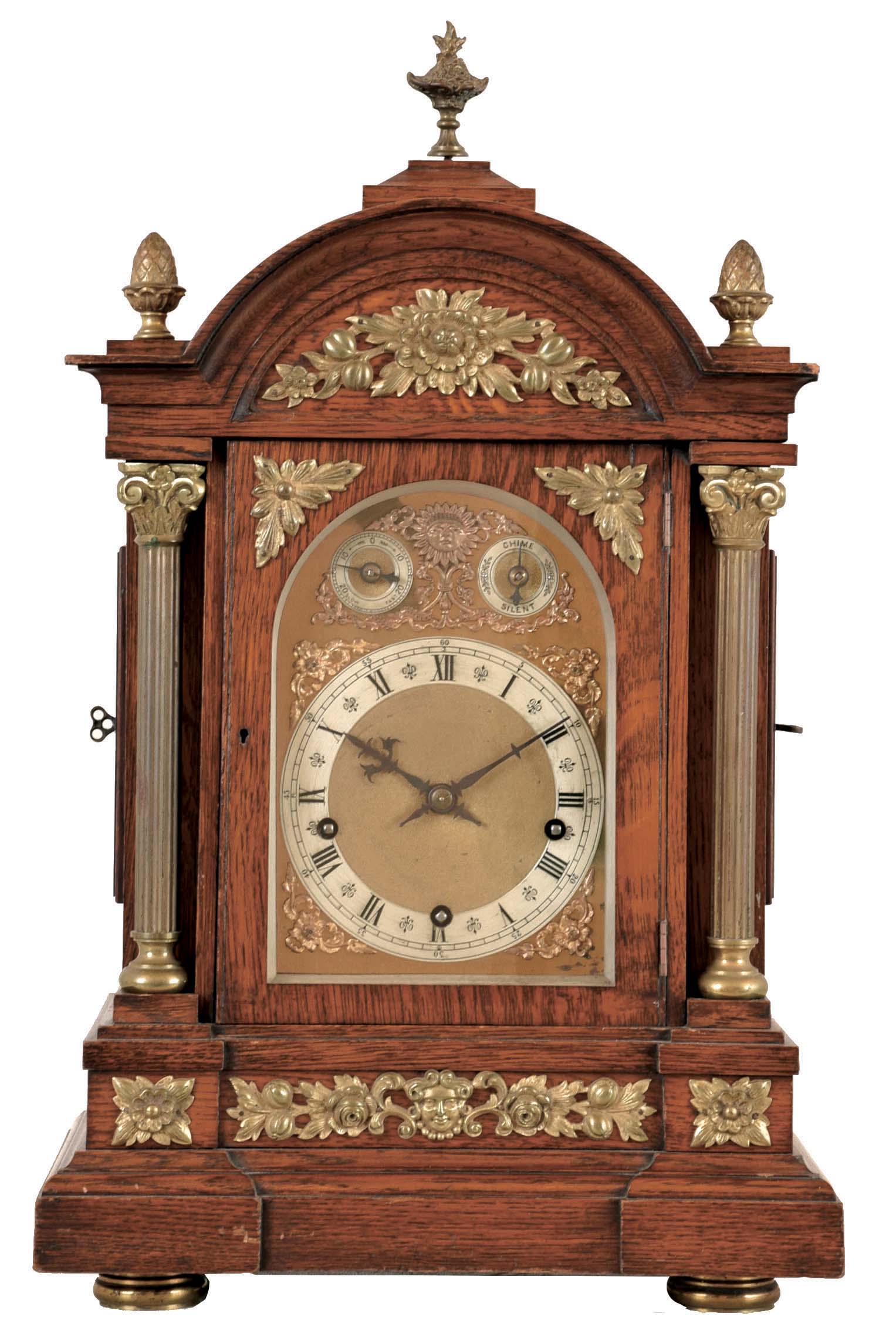 Winterhalder & Hofmeier, Germany, Westminster chime bracket clock, oak case with molded base and arched, molded top, with fluted columns, and applied foliate ornament, the composite dial with gilt spandrels, silvered chapter ring, chime and rate control dials, blued steel hands, 8 day, 3 train quarter chiming movement, sounding on 4 gongs at the quarters, and striking the hours on a larger gong, back plate signed — Antique Clocks Price Guide