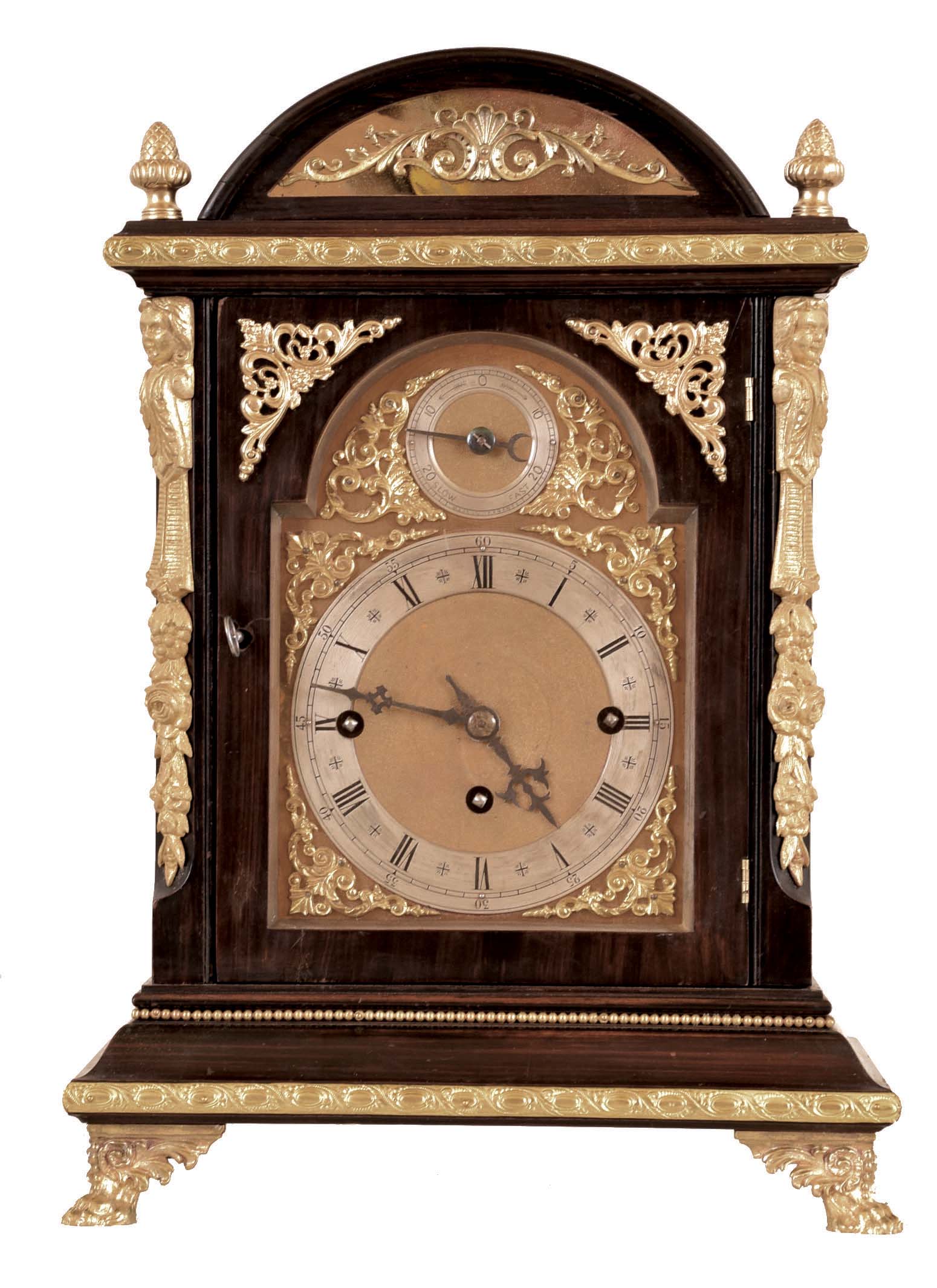 Winterhalder & Hofmeier, Germany, Westminster chime bracket clock, rosewood grained hardwood case with molded base and arched, molded top, and applied gilt ornament, the composite dial with gilt spandrels, silvered chapter ring, and rating control dial in the arch, blued steel hands, 8 day, 3 train quarter chiming fusee movement, sounding on 4 gongs at the quarters, and striking the hours on a larger gong, back plate signed — Antique Clocks Price Guide
