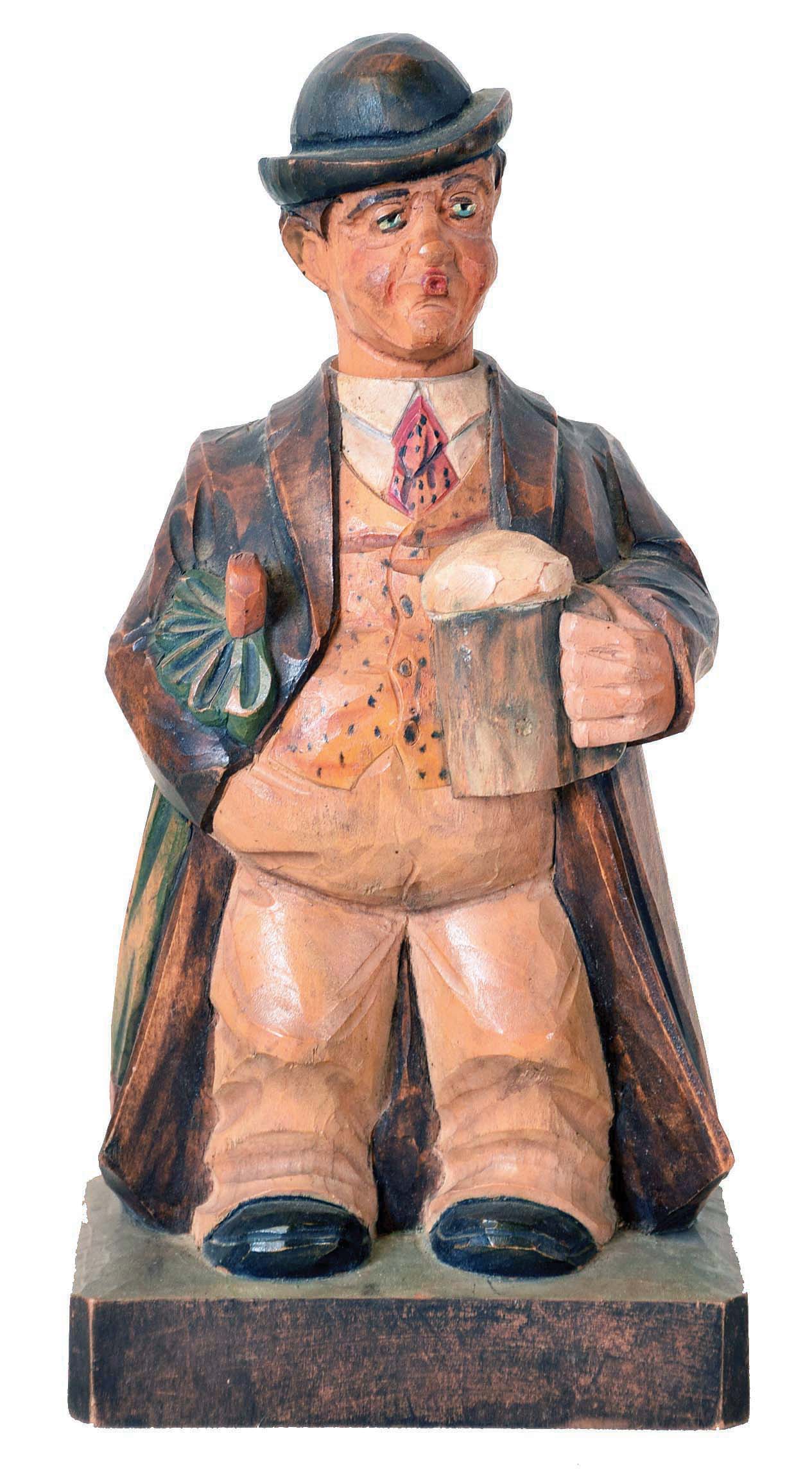 Karl Griesbaum, Germany, whistler, carved and painted figure of a man in hat and overcoat with umbrella tucked under his arm, enjoying a beer, his head moving from side to side and whistling a tune when activated by lever in his back, with "KG" logo on back and bottom — Antique Clocks Price Guide