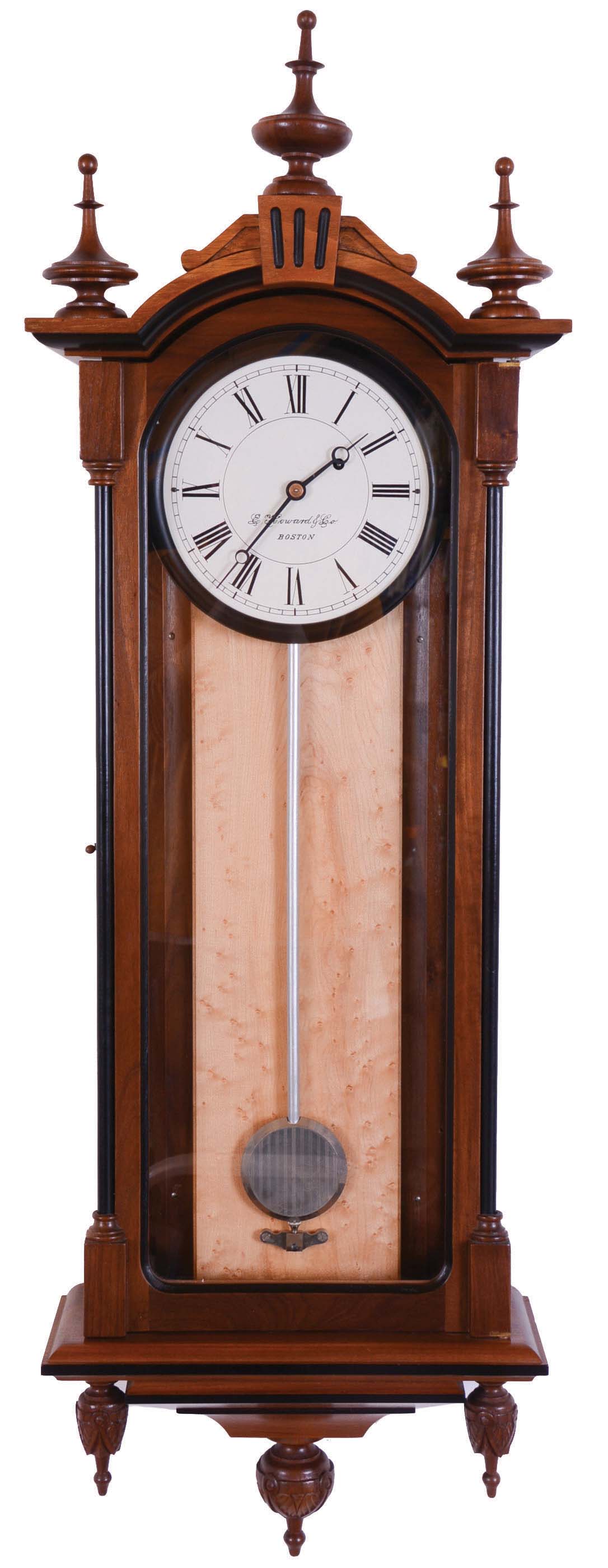 E. Howard & Co., Boston, Mass., "Regulator No. 59-8" reissue. Walnut case with ebonized moldings, turned and carved finials, maple weight baffle, ebonized wooden bezel with Roman numeral white painted 8" dial, blued steel moon hands, damascened nickel pendulum with silver painted wooden rod, 8 day weight driven timepiece movement, The clock has serial number 84 and is dated August, 1976. — Antique Clocks Price Guide