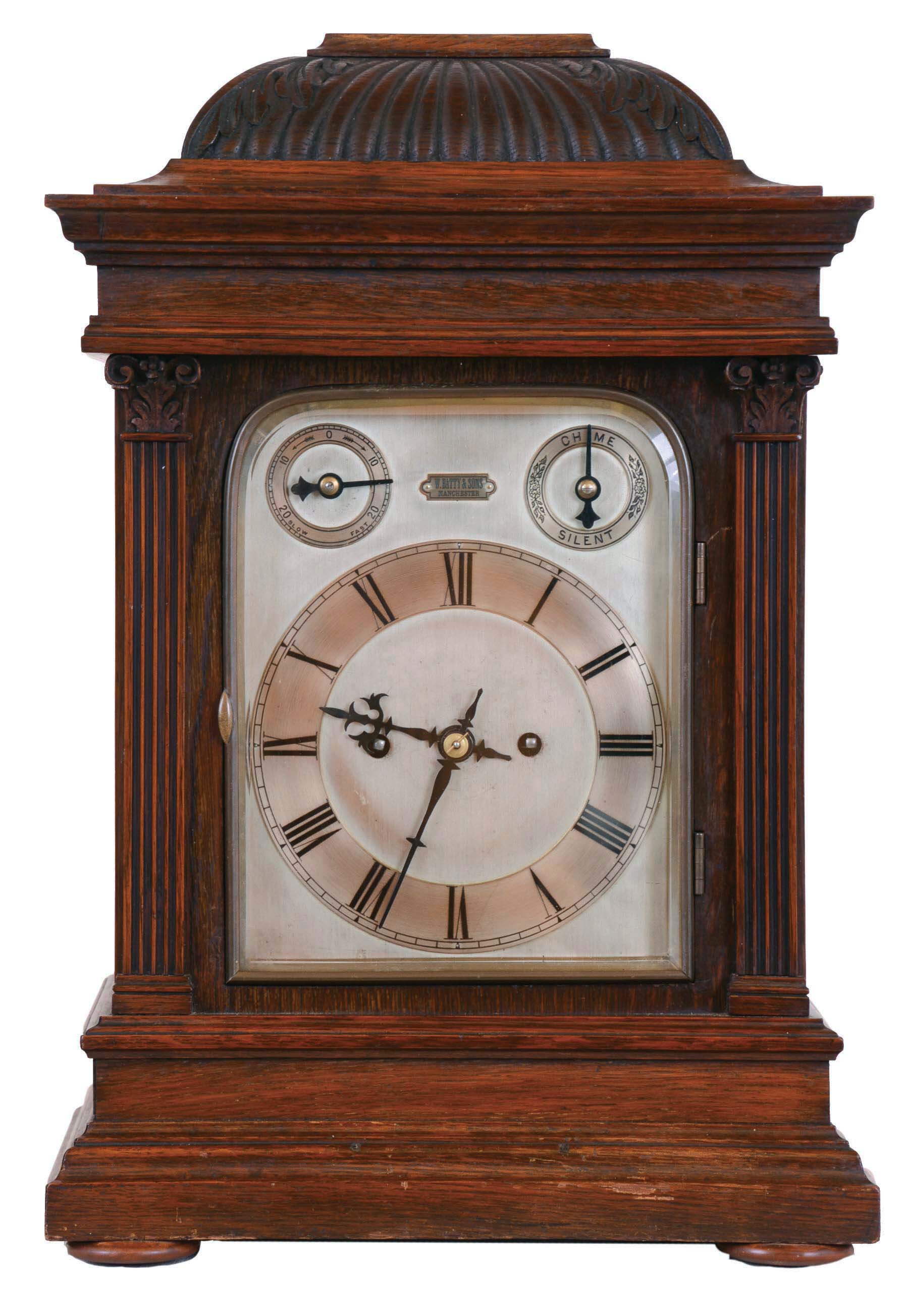 Winterhalder & Hofmeier, Germany, for W. Batty & Sons, Manchester, England, bracket clock, architectural oak case with fluted pilasters, gadrooned caddy top with acanthus carved corners, silvered dial with Roman numeral chapter ring, and with rating and chime control dials, blued steel hands, 8 day, 2 train fusee movement, with ting tang quarters and hour striking on gongs, back plate signed — Antique Clocks Price Guide