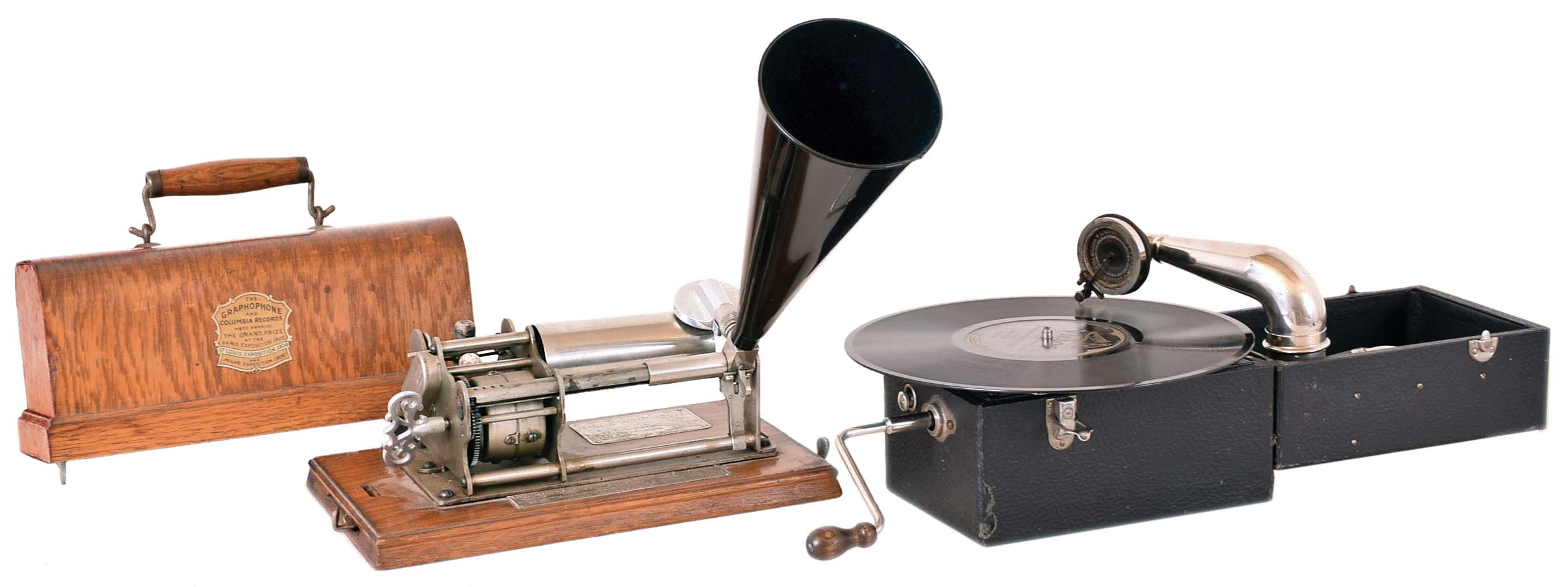Two (2) phonographs. (1) American Graph phone Co., New York, NY. "BX" model 2-minute wax cylinder phonograph sold by the Columbia Phonograph Co. with reproduction black cone horn. (2) KOMPAConn., phonograph made by the PLA/A Music Co., New York, NY with interior horn. — Antique Clocks Price Guide